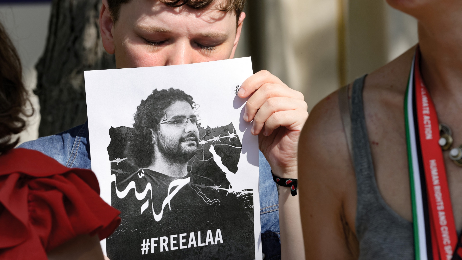 An activist holds a portrait of imprisoned Egyptian British blogger Alaa Abd el-Fattah during a protest in Dubai on 9 December 2023 (AFP)