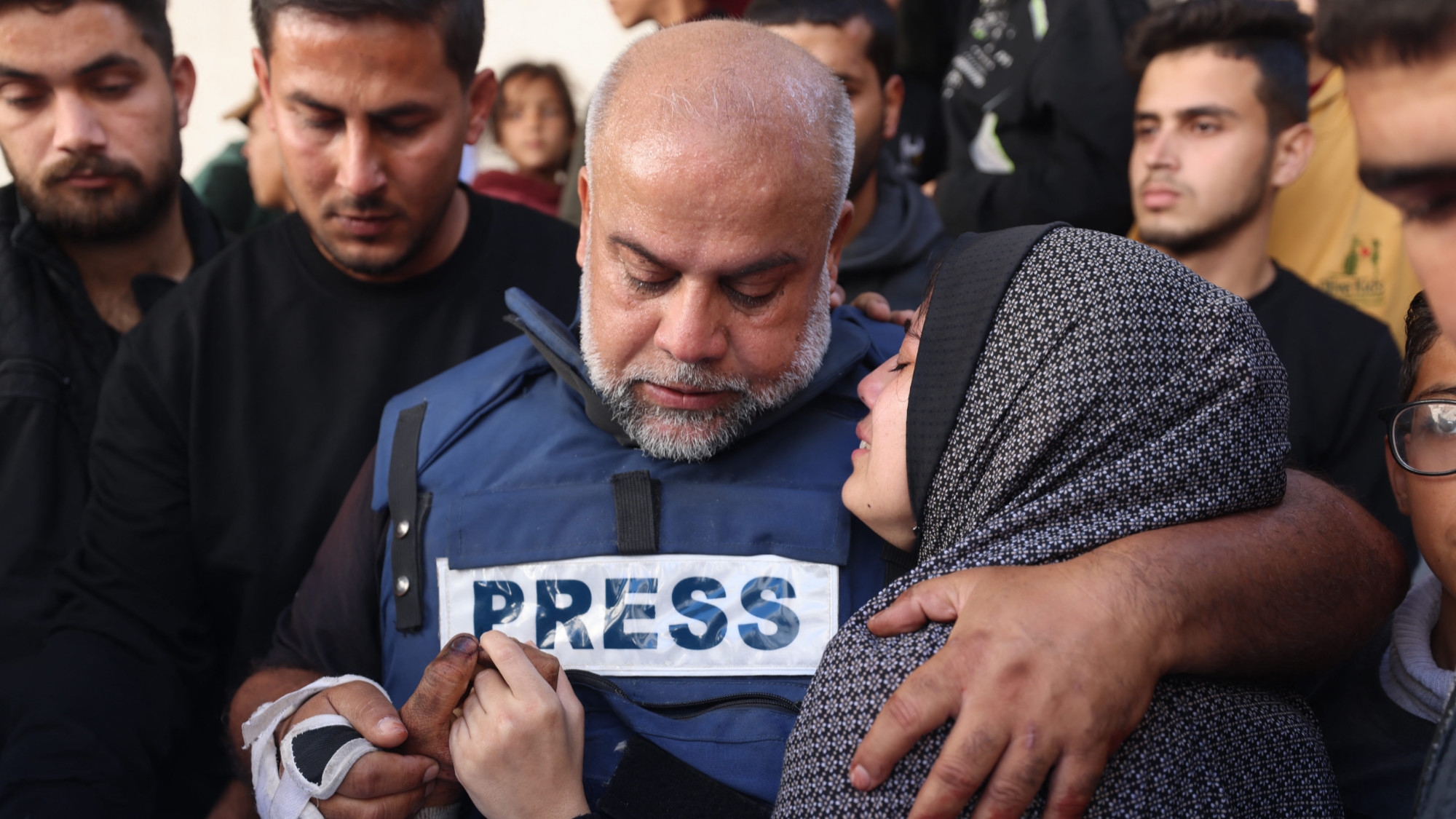 Al Jazeera's bureau chief in Gaza, Wael Al-Dahdouh (C) hugs his daughter during the funeral of his son Hamza Wael Dahdouh who was killed in an Israeli air strike 7 January 2024 (AFP)