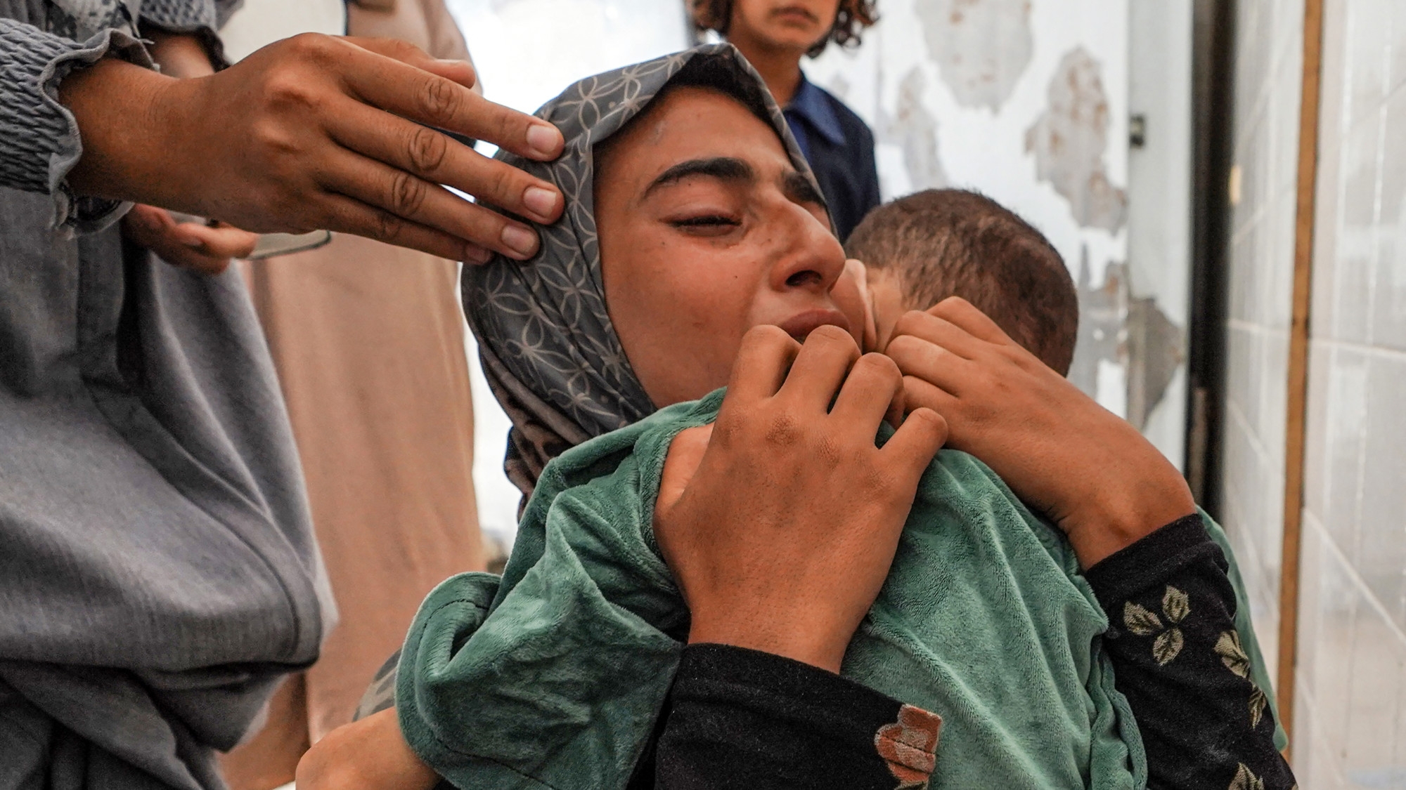 The body of Eyad Hegazi, a 10-year-old Palestinian child suffering from malnutrition,rests in the arms of his sister after he died at the Aqsa Martyrs hospital in Deir el-Balah 14 June 2024 (AFP/Bashar Taleb)