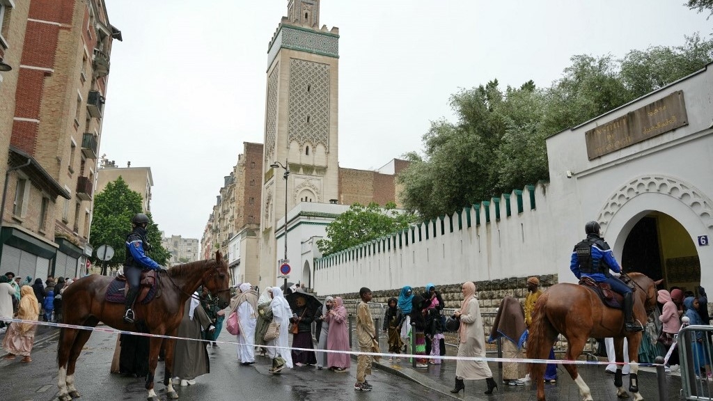 French gendarmes on their horses watch Muslim worshipers leaving the Great Mosque of Paris after the morning prayers on the first day of Islam's most important festival, the Feast of the Sacrifice (Eid al-Adha) on 16 June