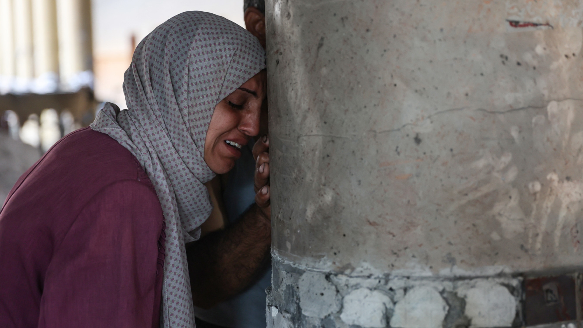 A woman cries inside a school used as a temporary shelter for displaced Palestinians in Gaza City after it was hit by an Israeli strike on 10 August 2024 (AFP/Omar al-Qattaa)