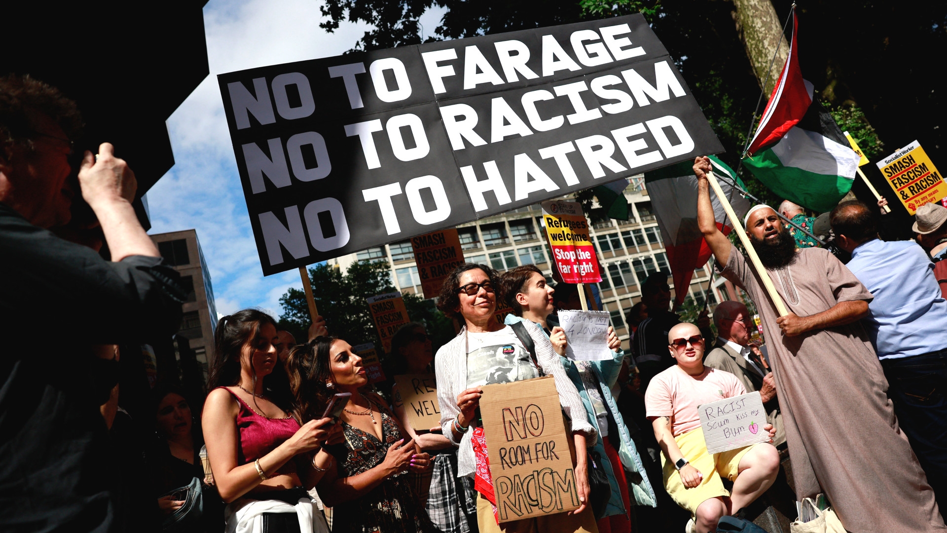 People hold anti-racism placards as they take part in a "Stop the Far Right" demonstration on a national day of protest outside the headquarters of the right-wing Reform UK political party in London on 10 August (Benjamin Cremel/AFP)