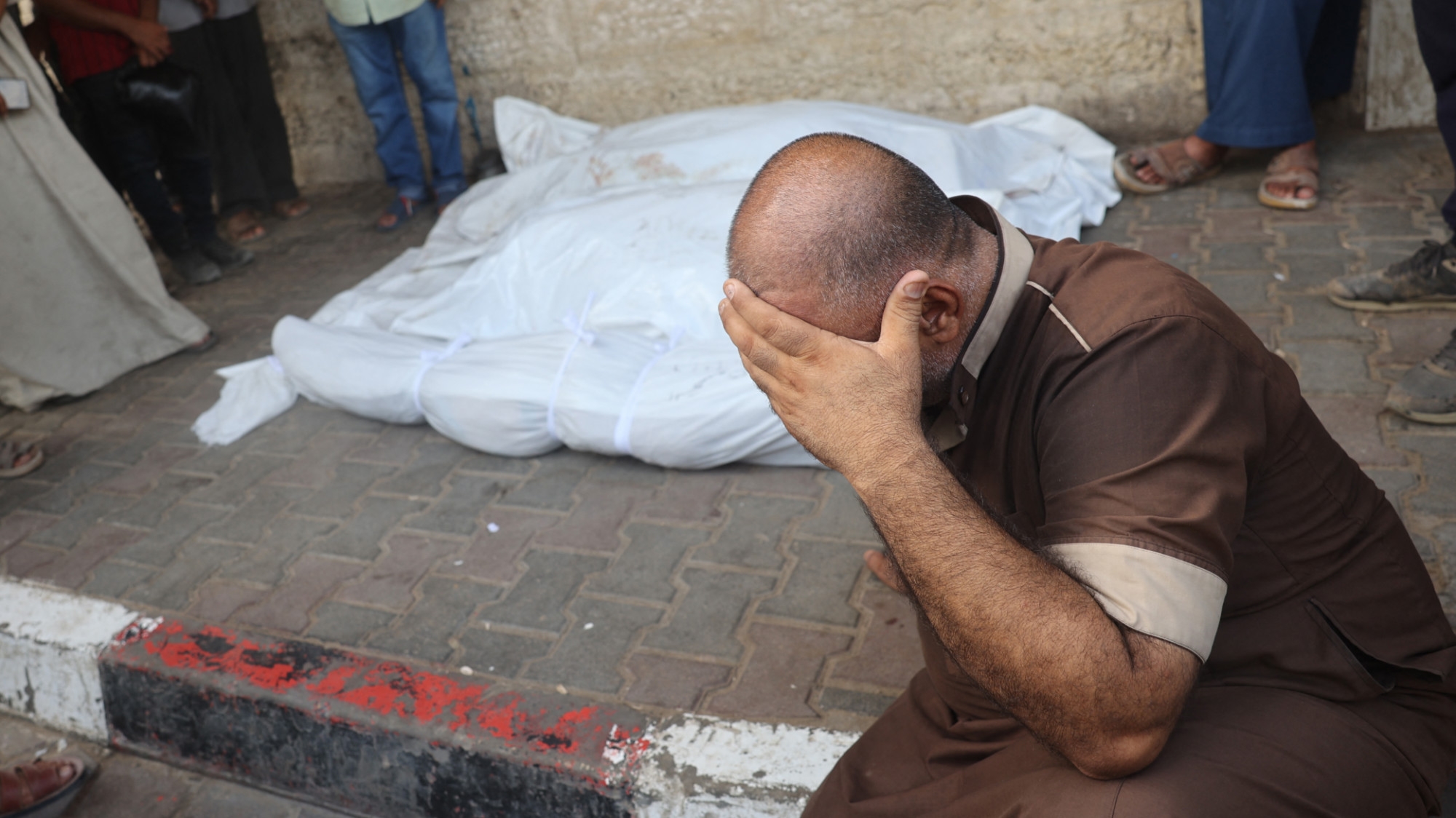 A Palestinian mourns his relatives, killed in an Israeli strike, at al-Aqsa Martyrs Hospital in Deir al-Balah, central Gaza Strip, on 17 August 2024 (AFP/Eyad Baba)