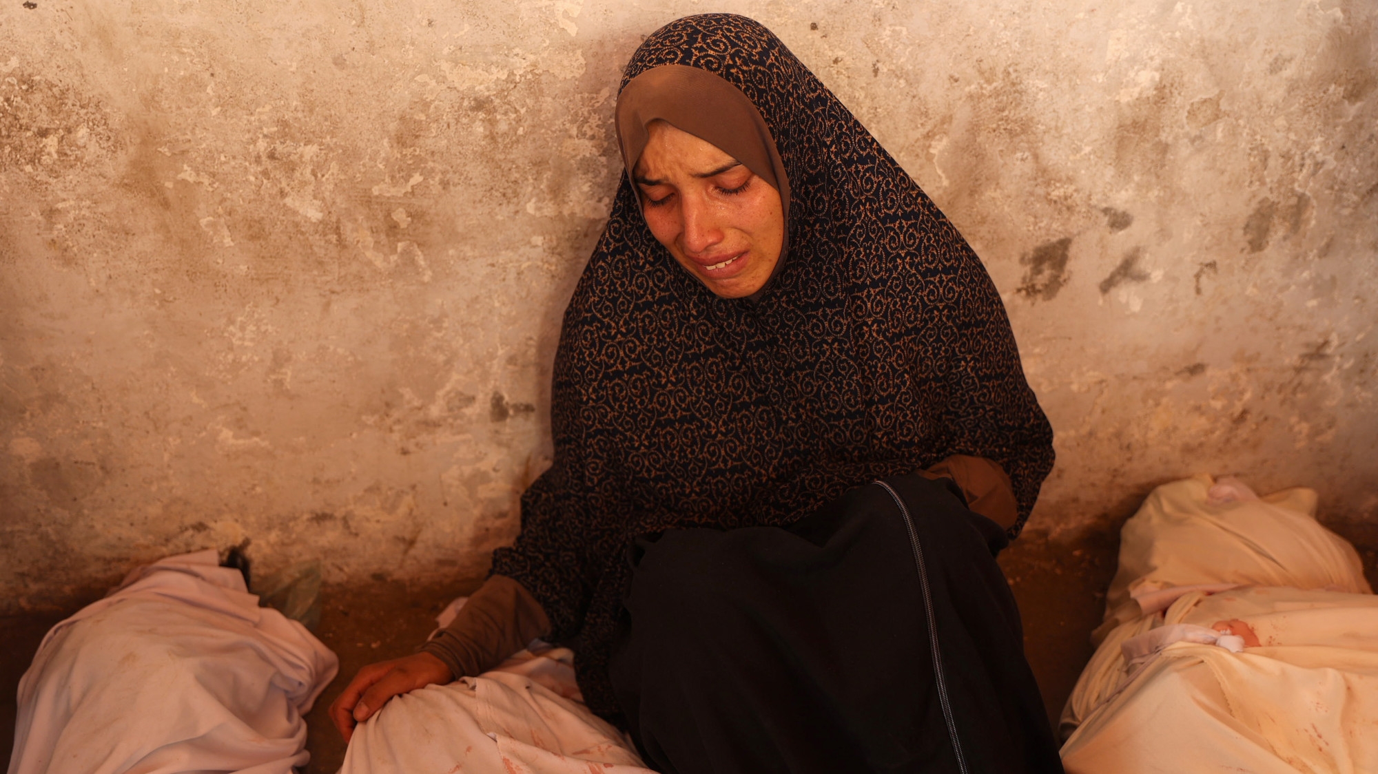 A Palestinian mourns over bodies of relatives after an Israeli strike on a school housing displaced Palestinians in Gaza City's Zaytoun neighbourhood on 21 September  2024 (AFP/Omar Al-Qattaa)