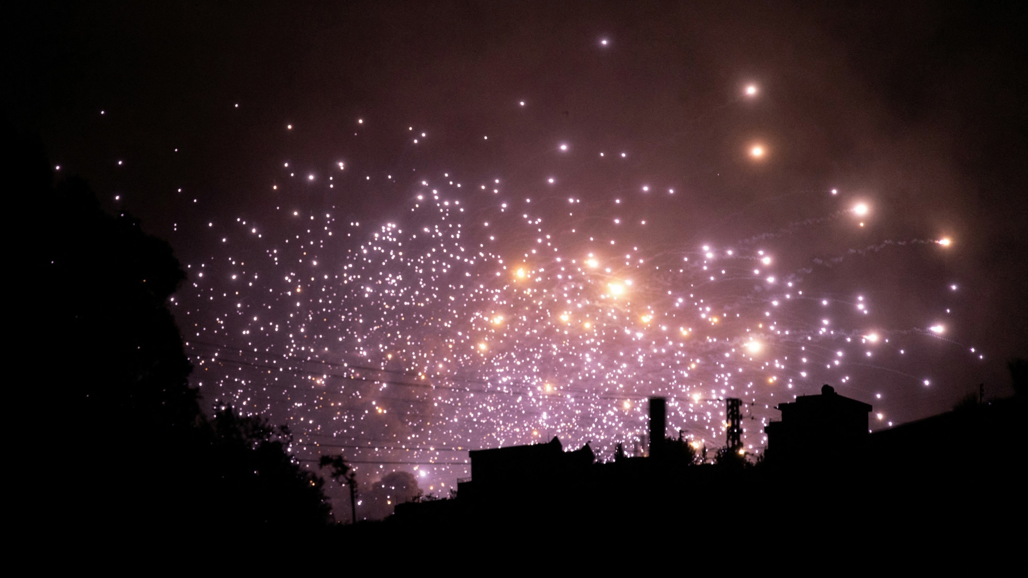 Sparks fly at the site of an Israeli air strike on the outskirts of the southern Lebanese village of Zawtar on 21 September  2024 (AFP)