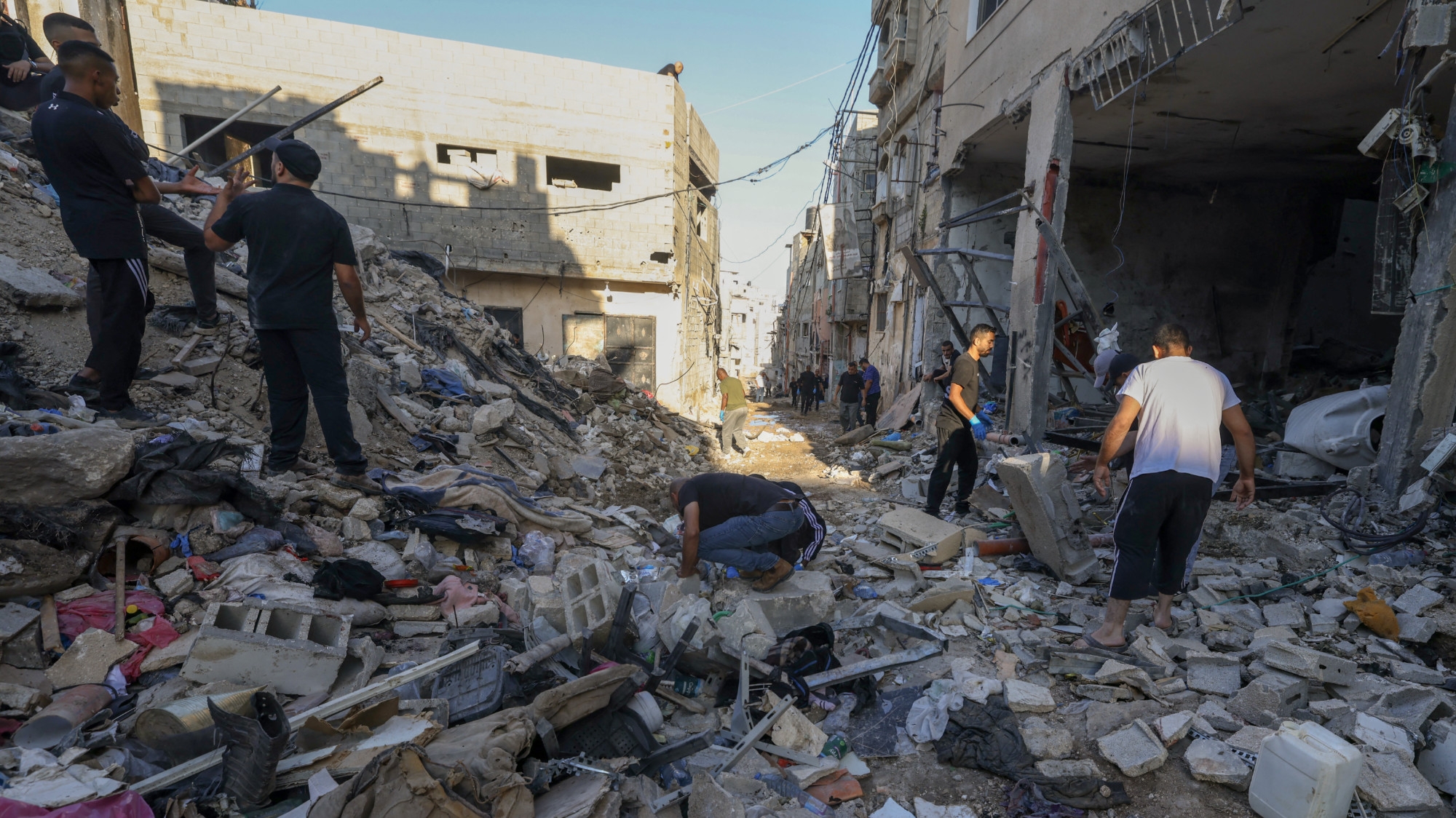 Palestinians inspect the damage at the site of an overnight Israeli air strike on the Tulkarem refugee camp in the occupied West Bank on 4 October 2024 (AFP/Jaafar Ashtiyeh)