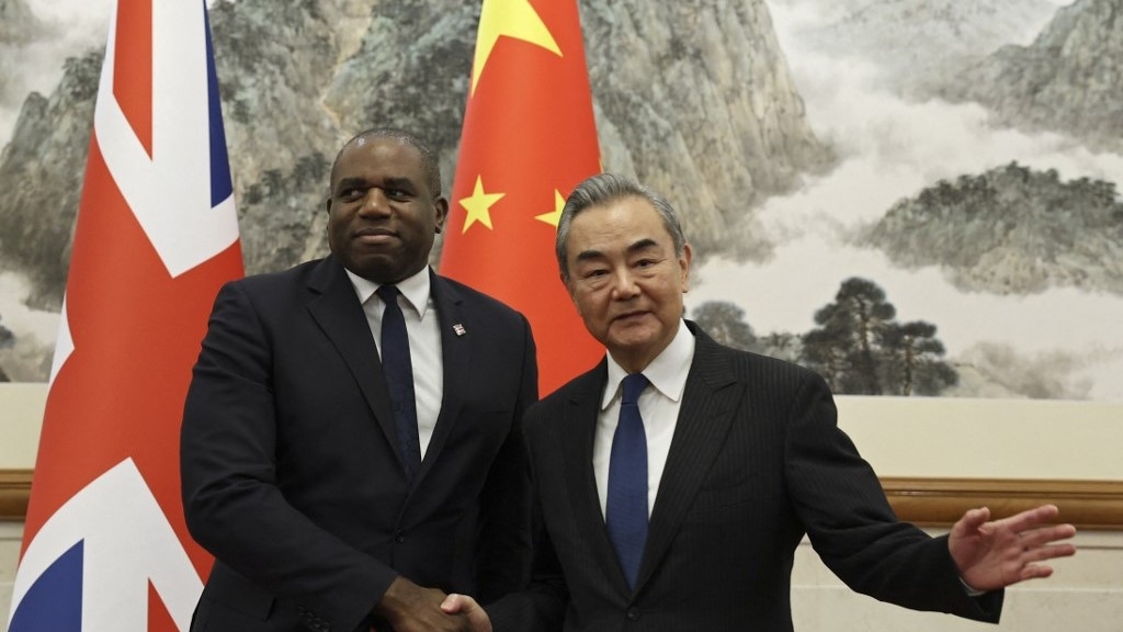 Britain's Foreign Secretary David Lammy and Chinese Foreign Minister Wang Yi shake hands before their meeting at the Diaoyutai State Guesthouse in Beijing on 18 October 