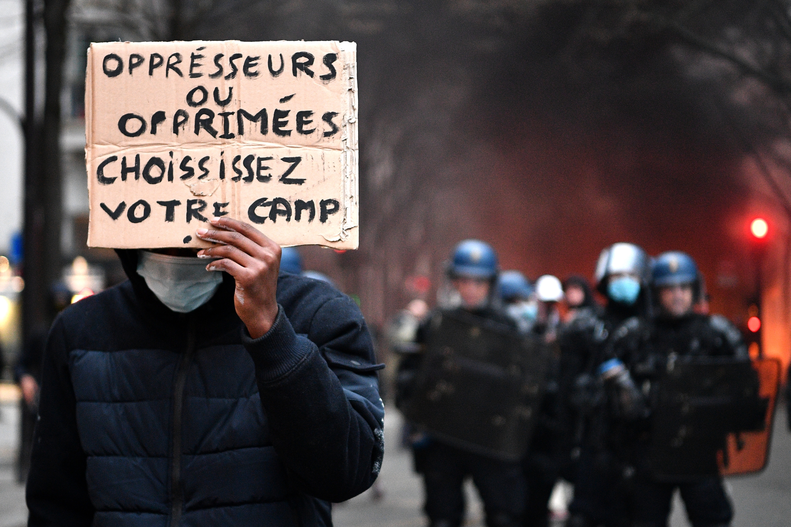 Un manifestant tient une pancarte lors d’une manifestation pour les « droits sociaux » et contre le projet de loi sur la « sécurité globale », à Paris, le 5 décembre 2020 (AFP)