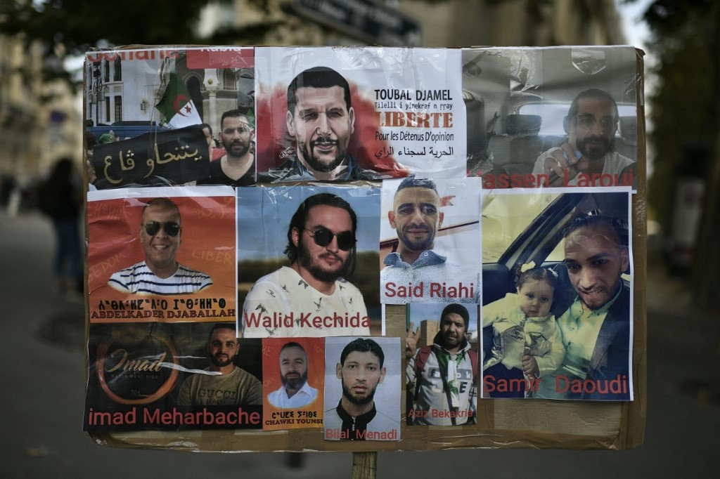 Une photo prise le 12 août 2020 montre des portraits de détenus algériens lors d’une manifestation à Paris devant l’ambassade d’Algérie (AFP)