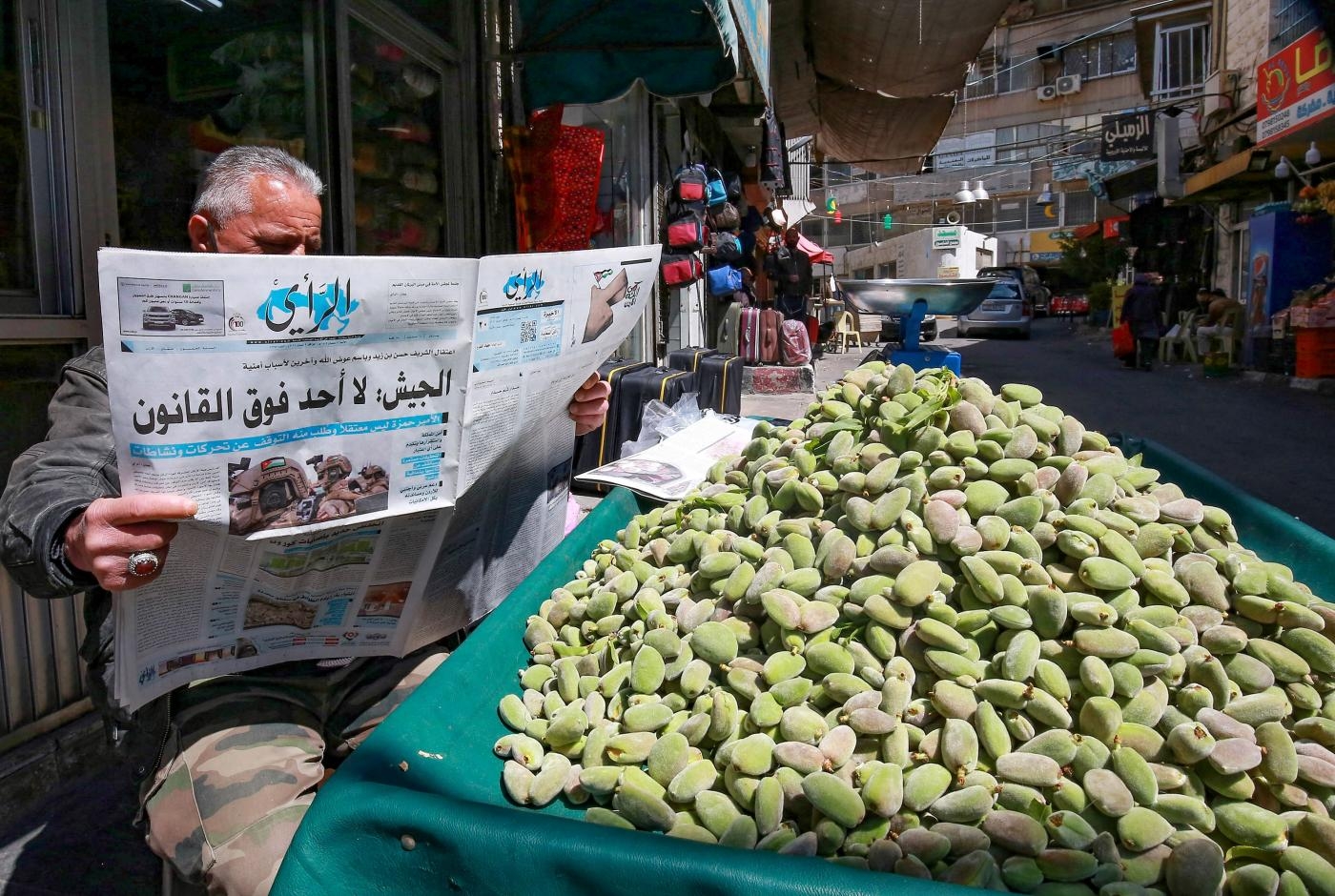 Un vendeur ambulant jordanien lit un journal local à Amman, le 4 avril 2021 (AFP)