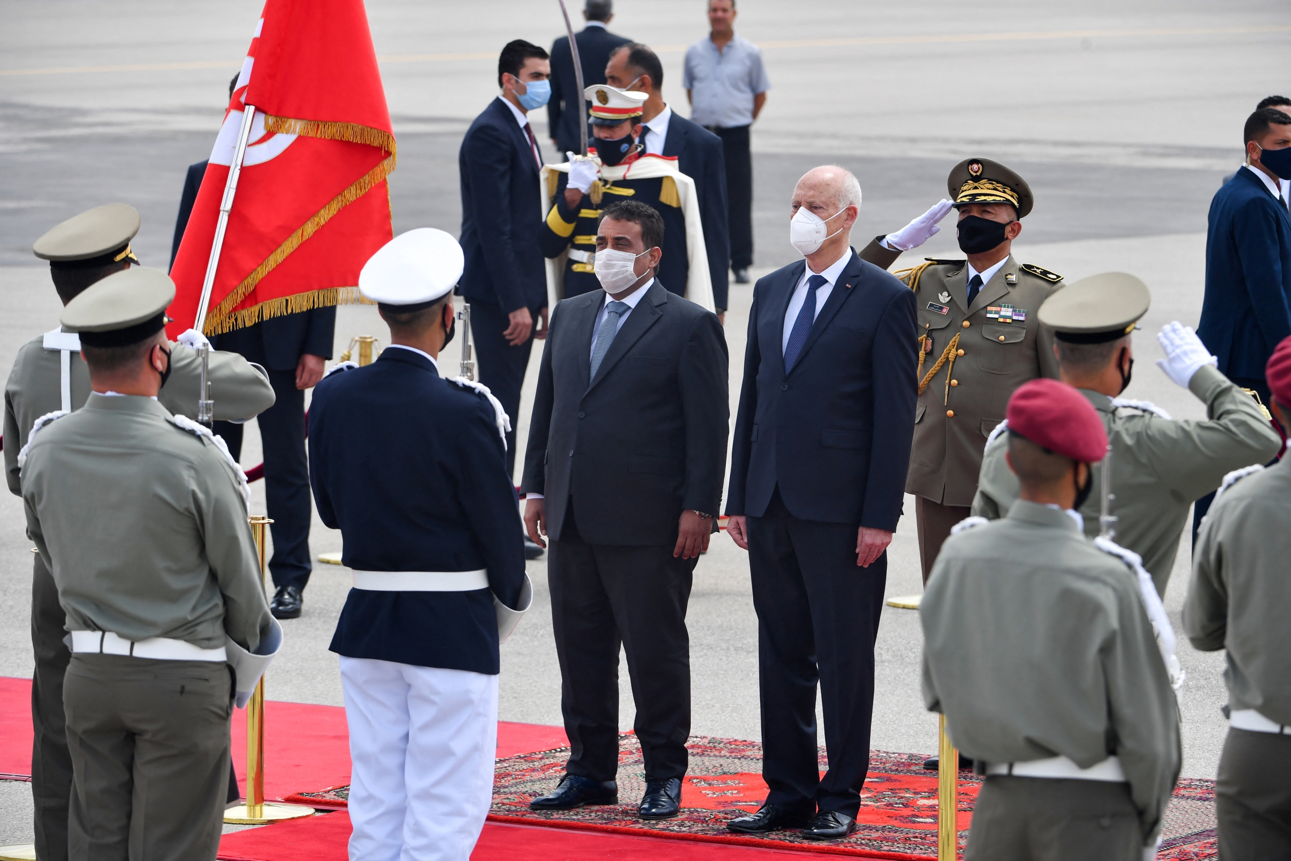 Le président tunisien Kais Saied (à droite) reçoit le président du Conseil présidentiel libyen Mohamed el-Menfi (à gauche) à son arrivée à l’aéroport de Tunis, le 29 mai 2021 (AFP)
