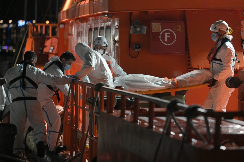 Des urgentistes espagnols débarquent le corps d’un migrant décédé, dans le port d’Arguineguín, sur la côte de l'île de Gran Canaria, le 18 novembre 2021 (AFP/Lluis Gene)