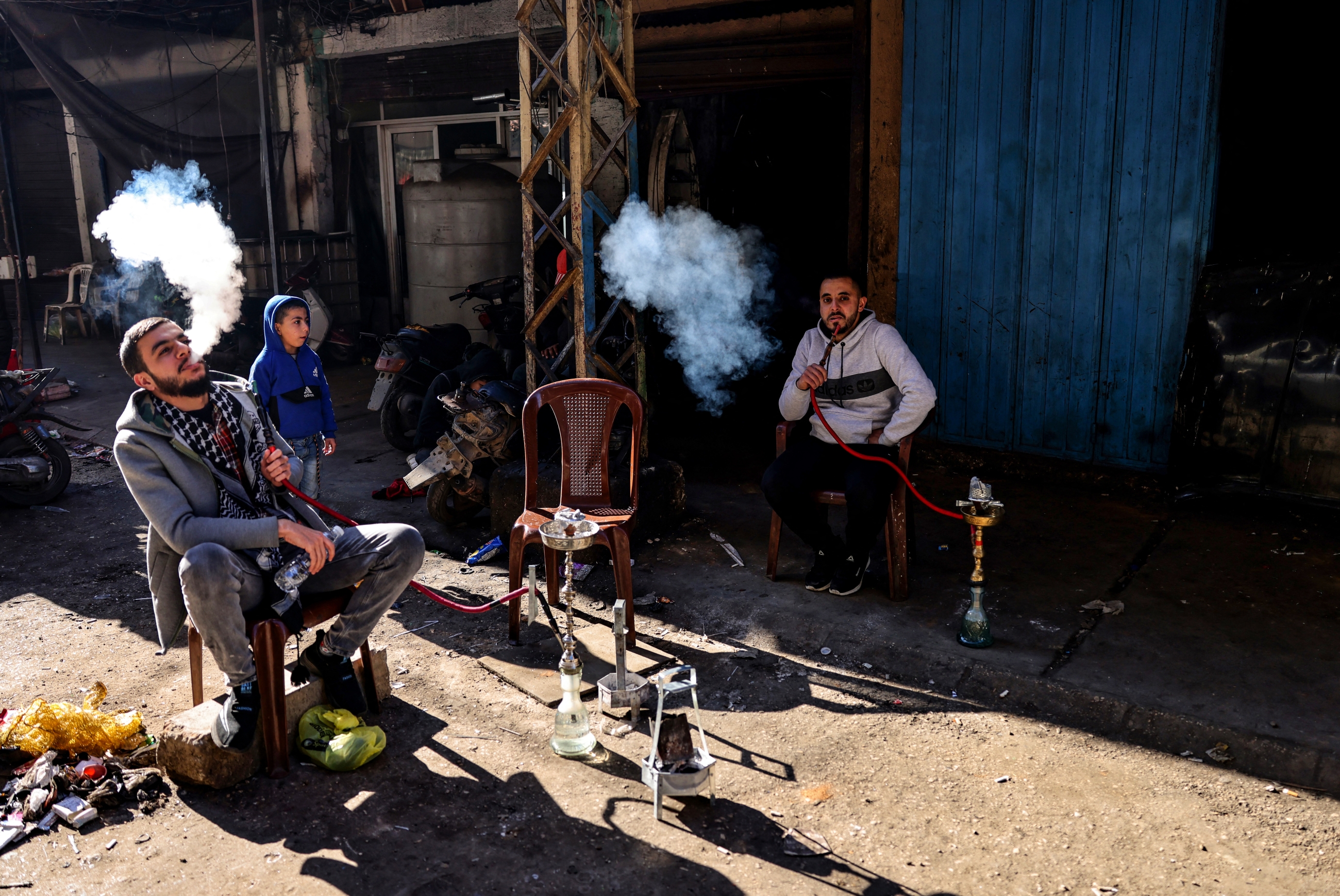 Des Libanais font une pause devant leur atelier dans une ruelle du quartier pauvre de Bab al-Tabbaneh, dans le nord de Tripoli (AFP/Joseph Eid)