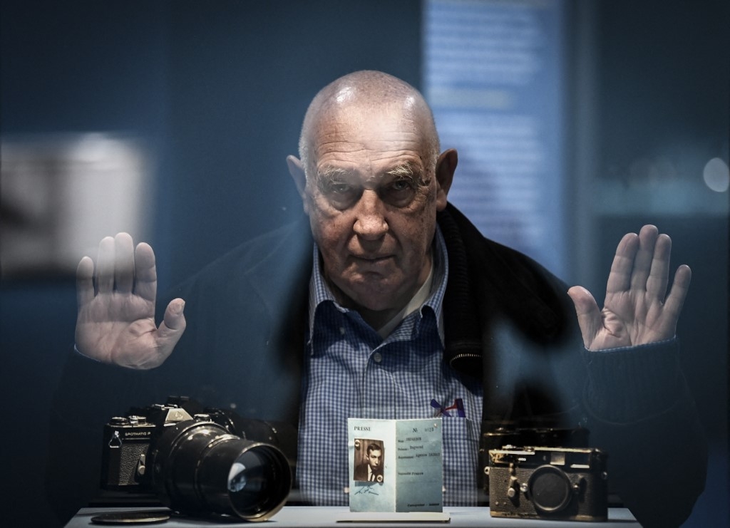 Le photographe français Raymond Depardon pose devant ses appareils photos à l’Institut du monde arabe à Paris, le 3 février 2022 (AFP/Stephane De Sakutin)