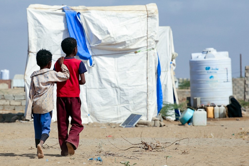 Children walk in front of tents at a camp for displaced Yemenis in the village of Hays, near the western province of Hodeida, on 5 February 2022 