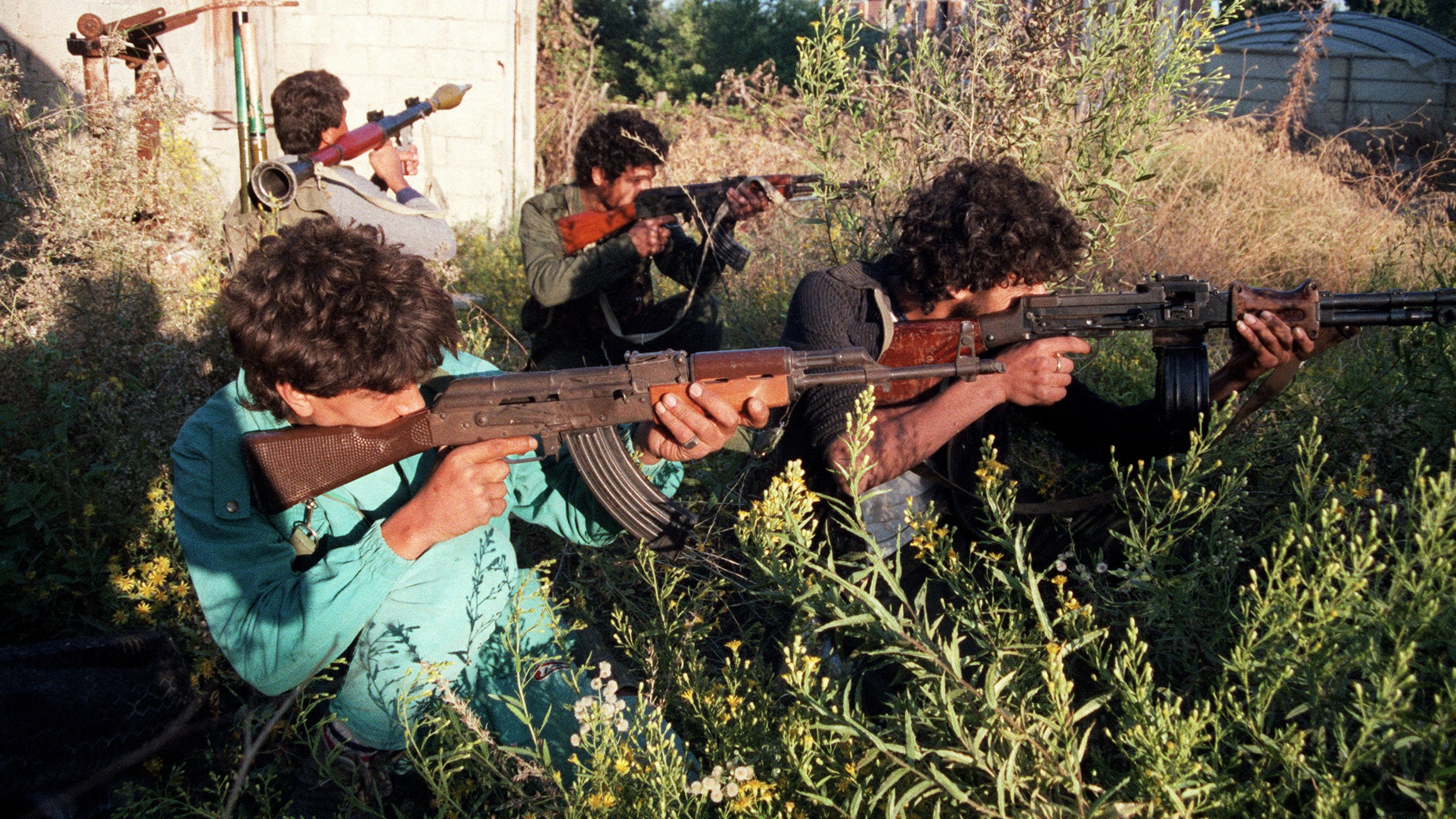 Palestinian pro-Arafat fighters survey the area of the Saida refugee camp, 25 October 1986 (Hilal Habli/AFP)