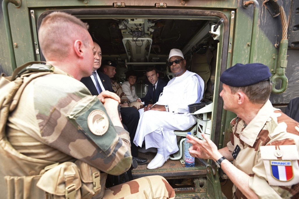 Le président français Emmanuel Macron et le ministre français des Affaires étrangères Jean-Yves Le Drian discutent avec le président malien Ibrahim Boubacar Keïta à l’intérieur d’un véhicule militaire alors qu’ils visitent les troupes de l’opération Barkhane, dans la région africaine du Sahel à Gao, dans le nord du Mali, le 19 mai 2017 (AFP)