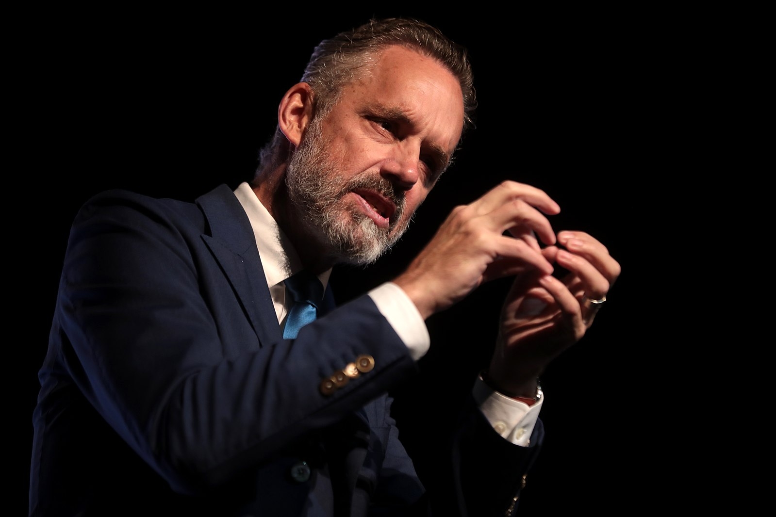 Jordan Peterson delivering a speech at a podium with a focused expression on his face. (Wikimedia Commons)