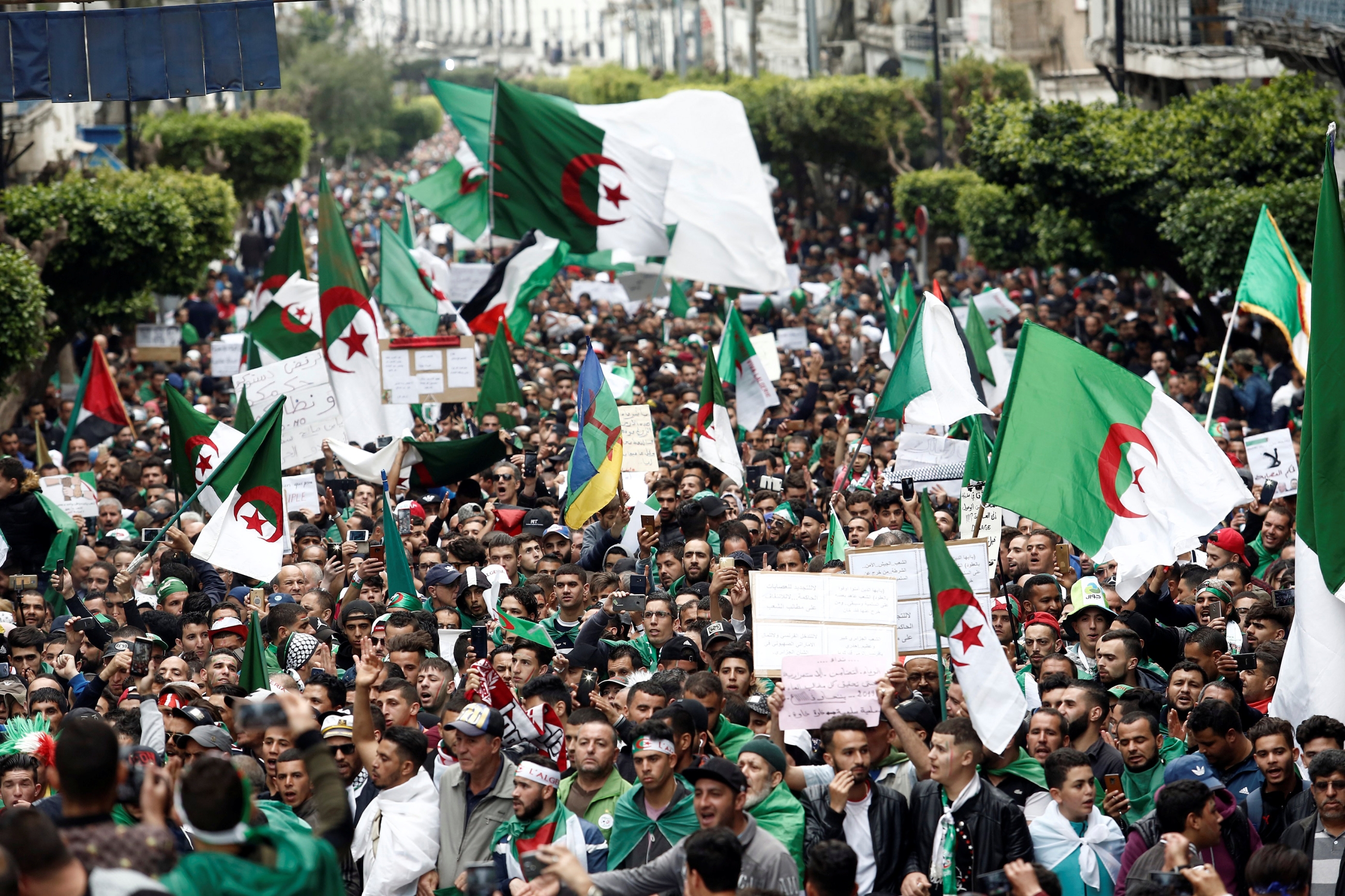 Protesters hold flags and banners in Algiers as they press demands for democratic change, April 19, 2019. 