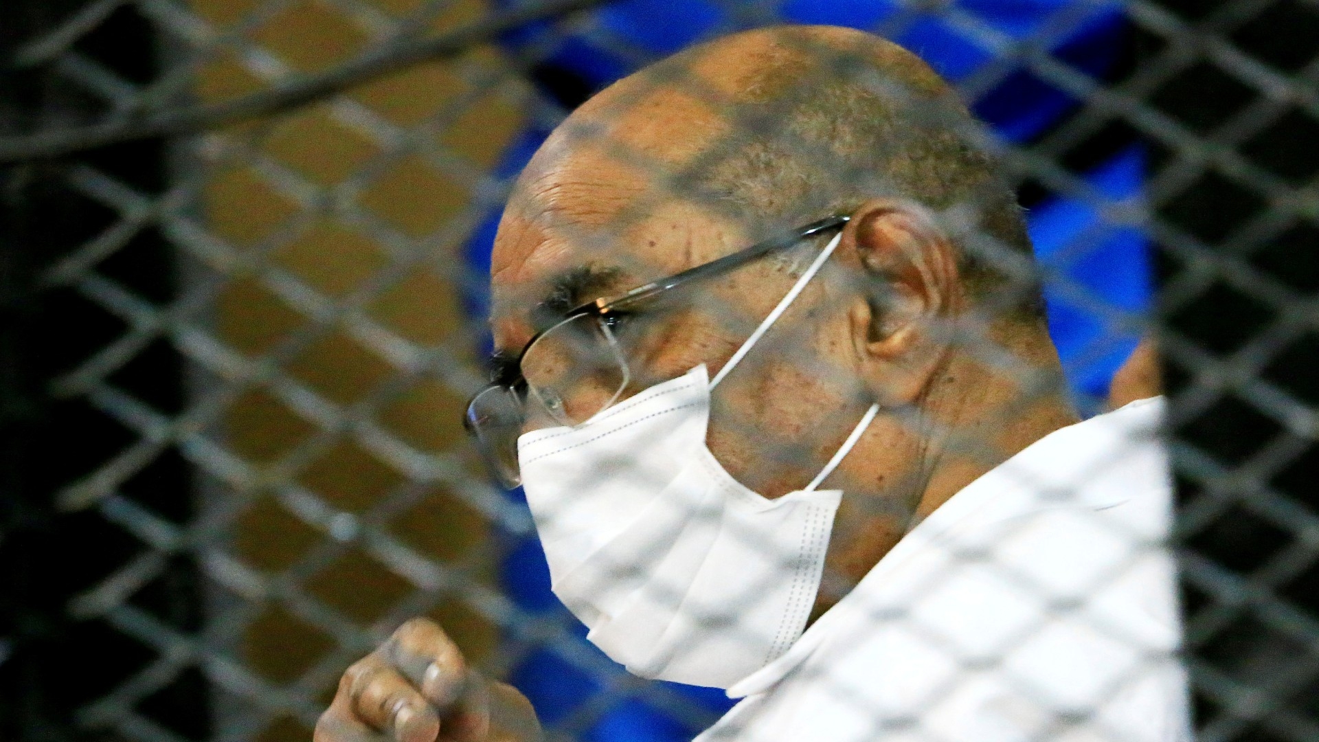Omar al-Bashir is seen inside the defendant's cage during his trial over the 1989 military coup that brought the autocrat to power in 1989, at a courthouse in Khartoum in 2020 (Reuters)