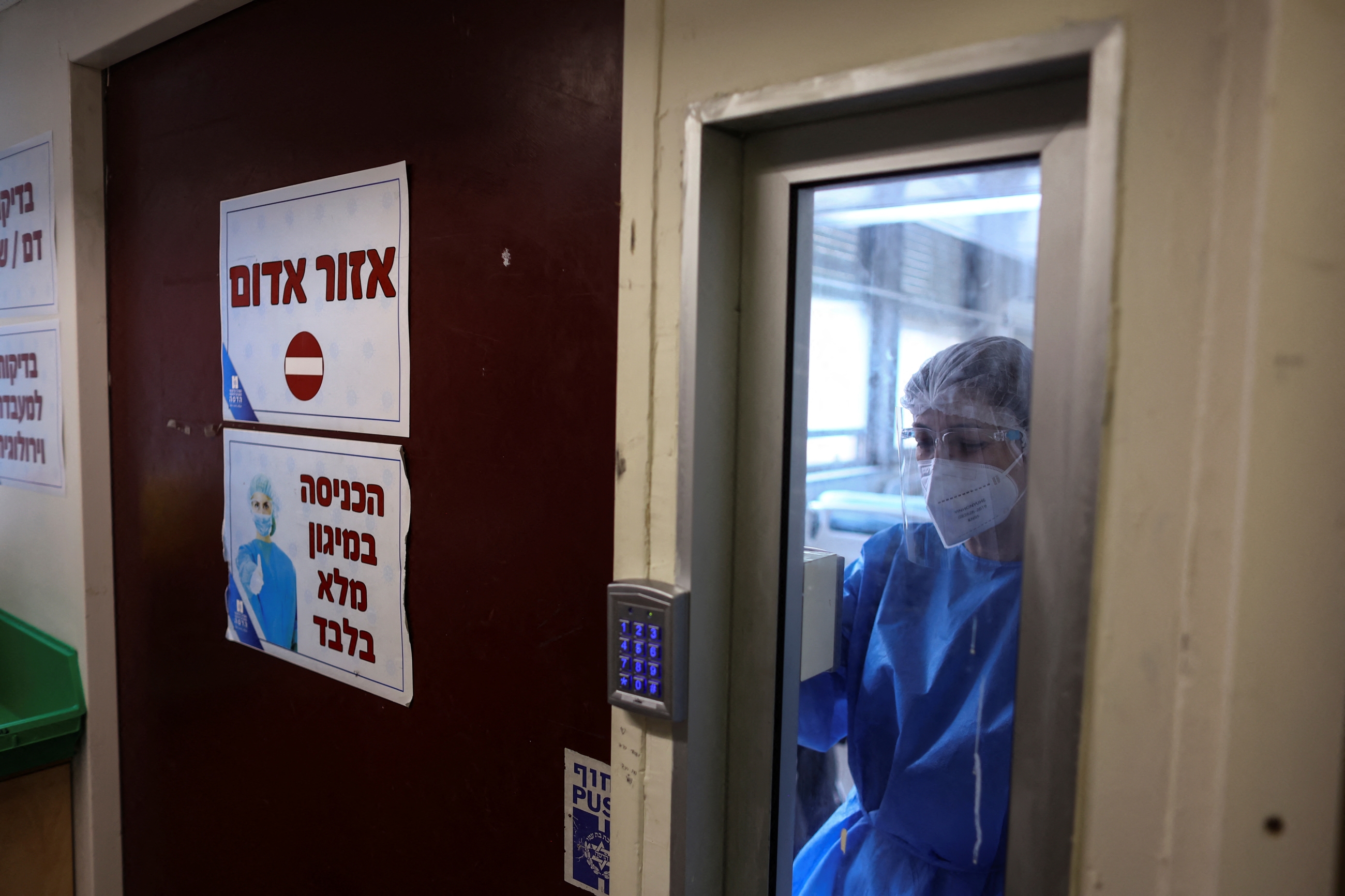 A medical staff member uses a code to exit the coronavirus ward at Hadassah Ein Kerem Hospital, in Jerusalem 31 January 2022 (Reuters) 