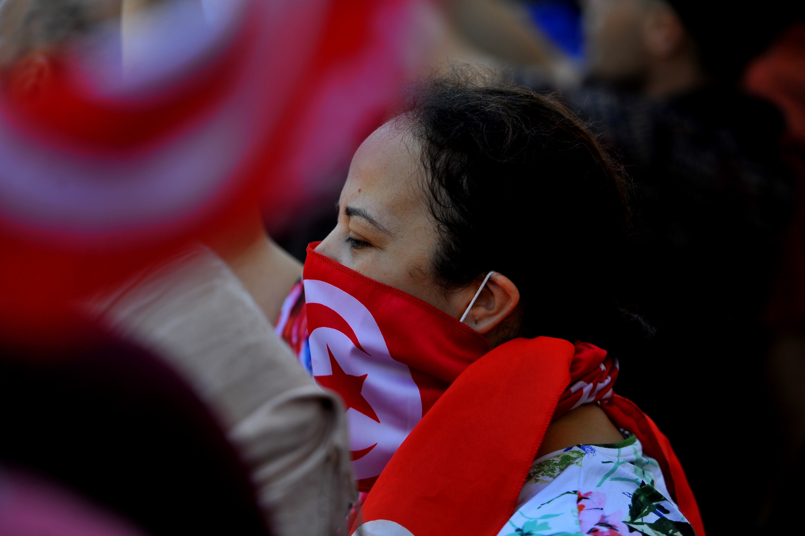 Tunisian protesters raise flags and placards on 23 July 2022, during an anti-Saied demonstration in the capital Tunis. (Reuters)