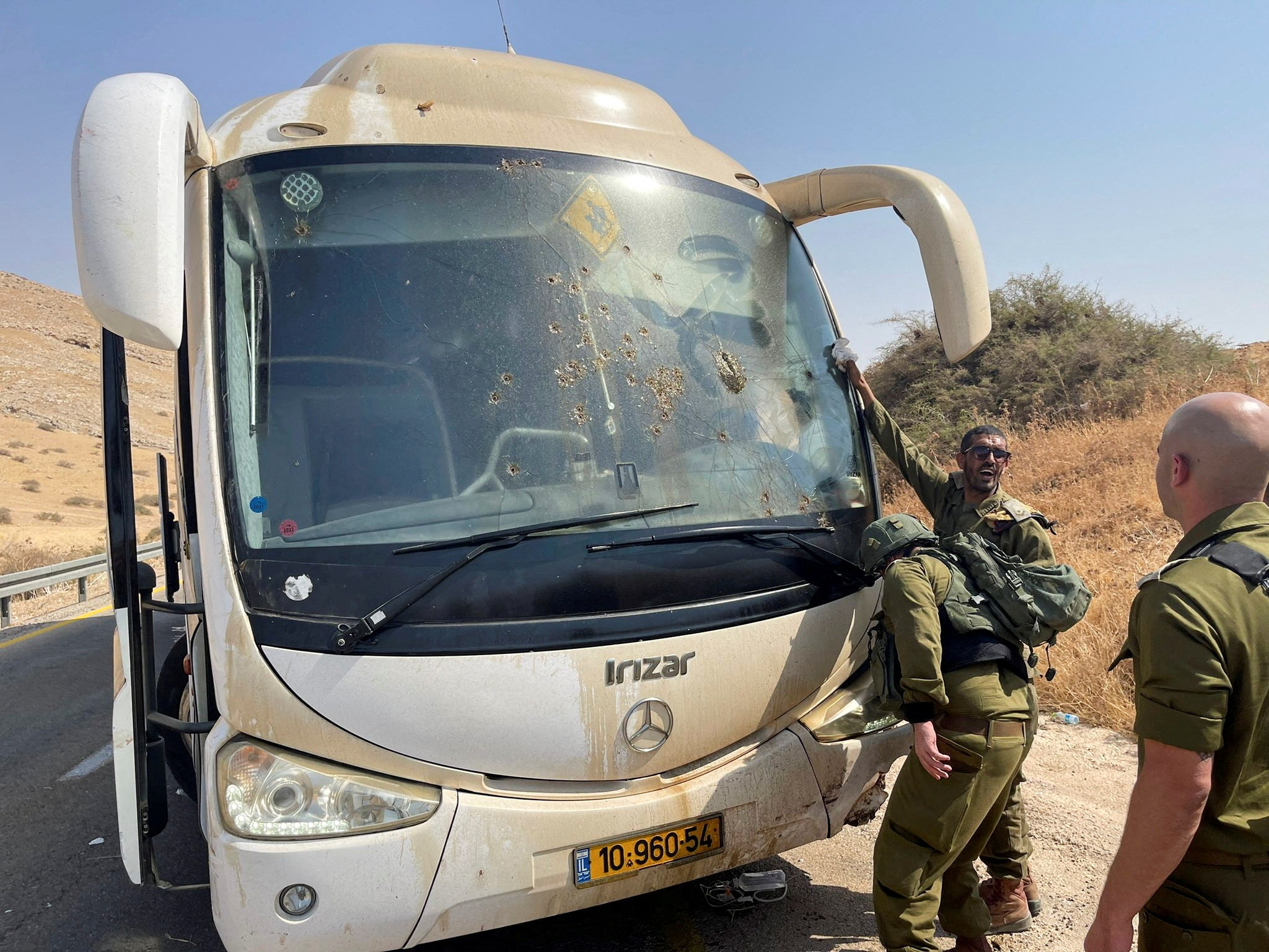 Israeli soldiers check damage in a bus, at the scene of a shooting attack in the Jordan Valley, in the Israeli-occupied West Bank 4 September 2022 (Reuters)