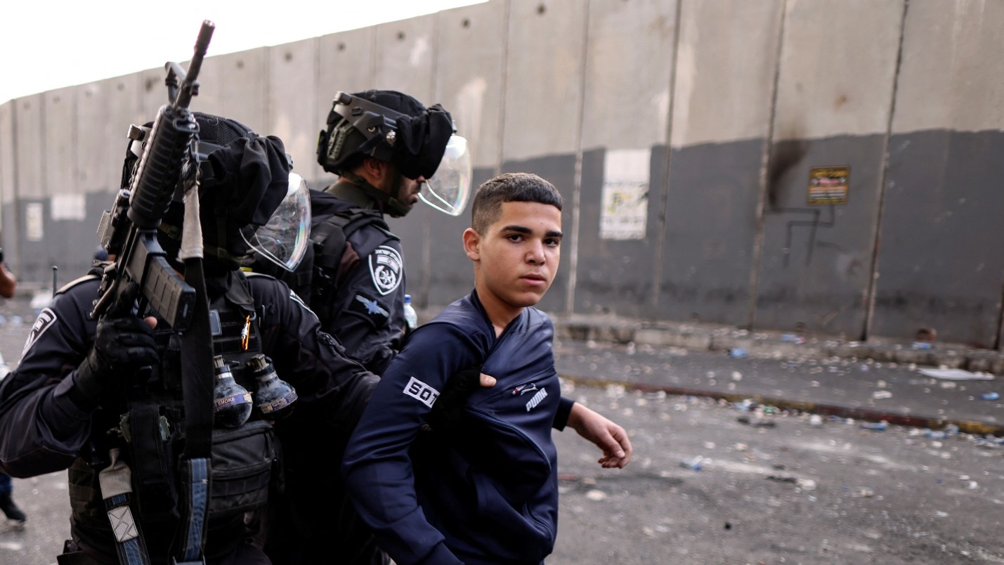 Israeli police detain a Palestinian youth in the Shuafat refugee camp in East Jerusalem on 12 October (Reuters)