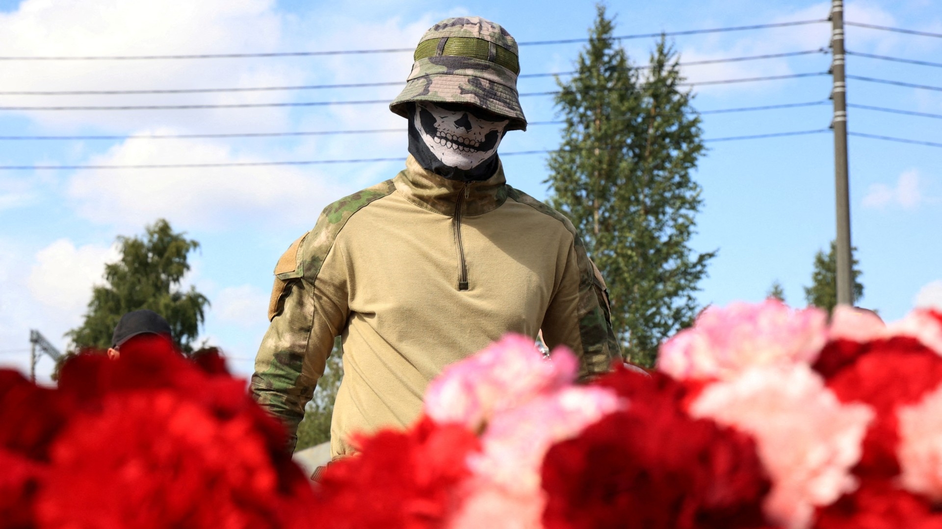 A Wagner fighter visits a makeshift memorial near former PMC Wagner Centre, associated with Yevgeny Prigozhin, in St Petersburg 24 August (Reuters)