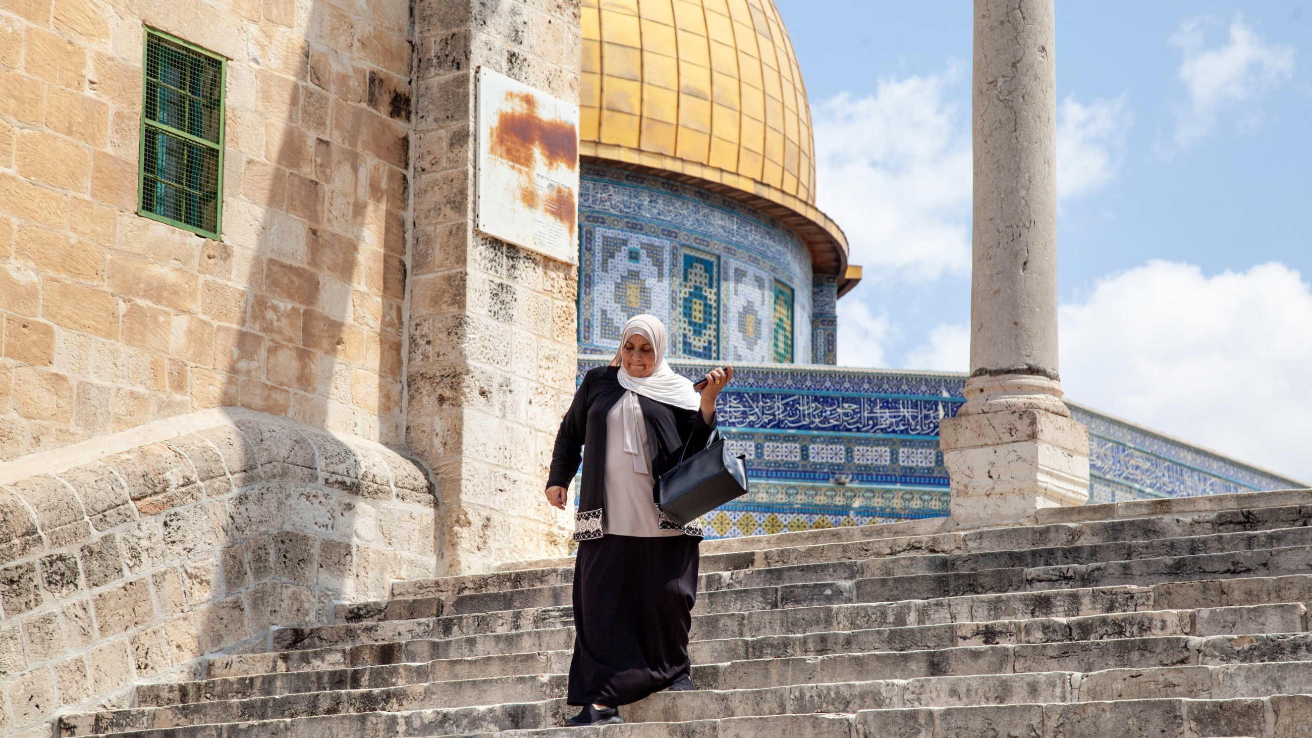 Palestinian woman walks down the stairs next to the Dome of the Rock in al-Aqsa Mosque in occupied East Jerusalem on 29 August 2023 (Hans Lucas via Reuters)