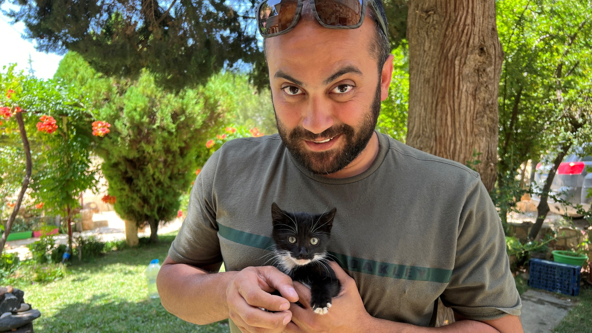 Reuters journalist Issam Abdallah holds a kitten while posing for a picture in Saida, Lebanon 4 July 2023 (Reuters)