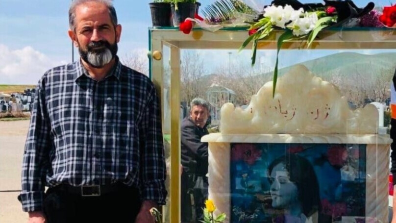 Amjad Amini standing by his daughter's grave in Saqqez, Iran in 2023 (ANF)