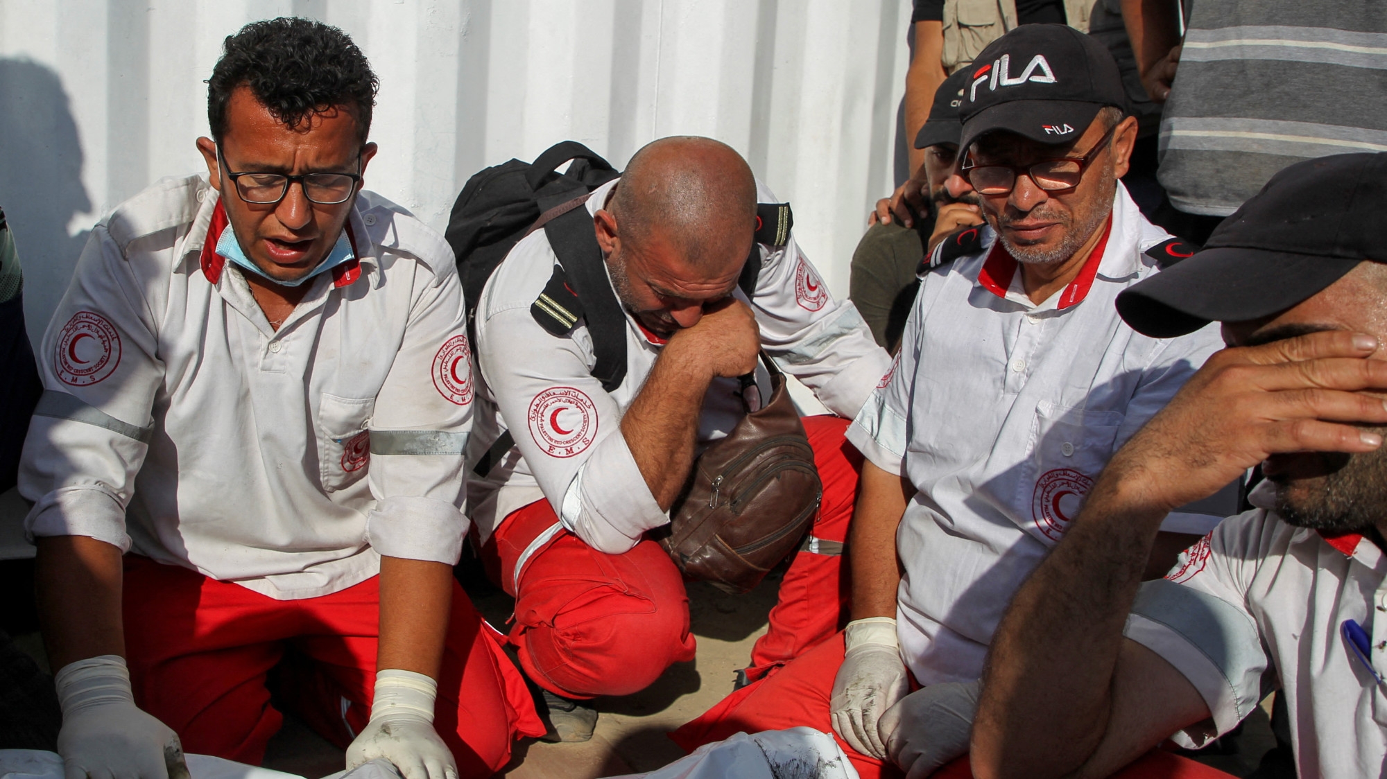 Palestinian members of the Palestine Red Crescent Society (PRCS) mourn two fellow paramedics killed by Israeli forces in Rafah on 30 May 2024 (Reuters/Hatem Khaled)