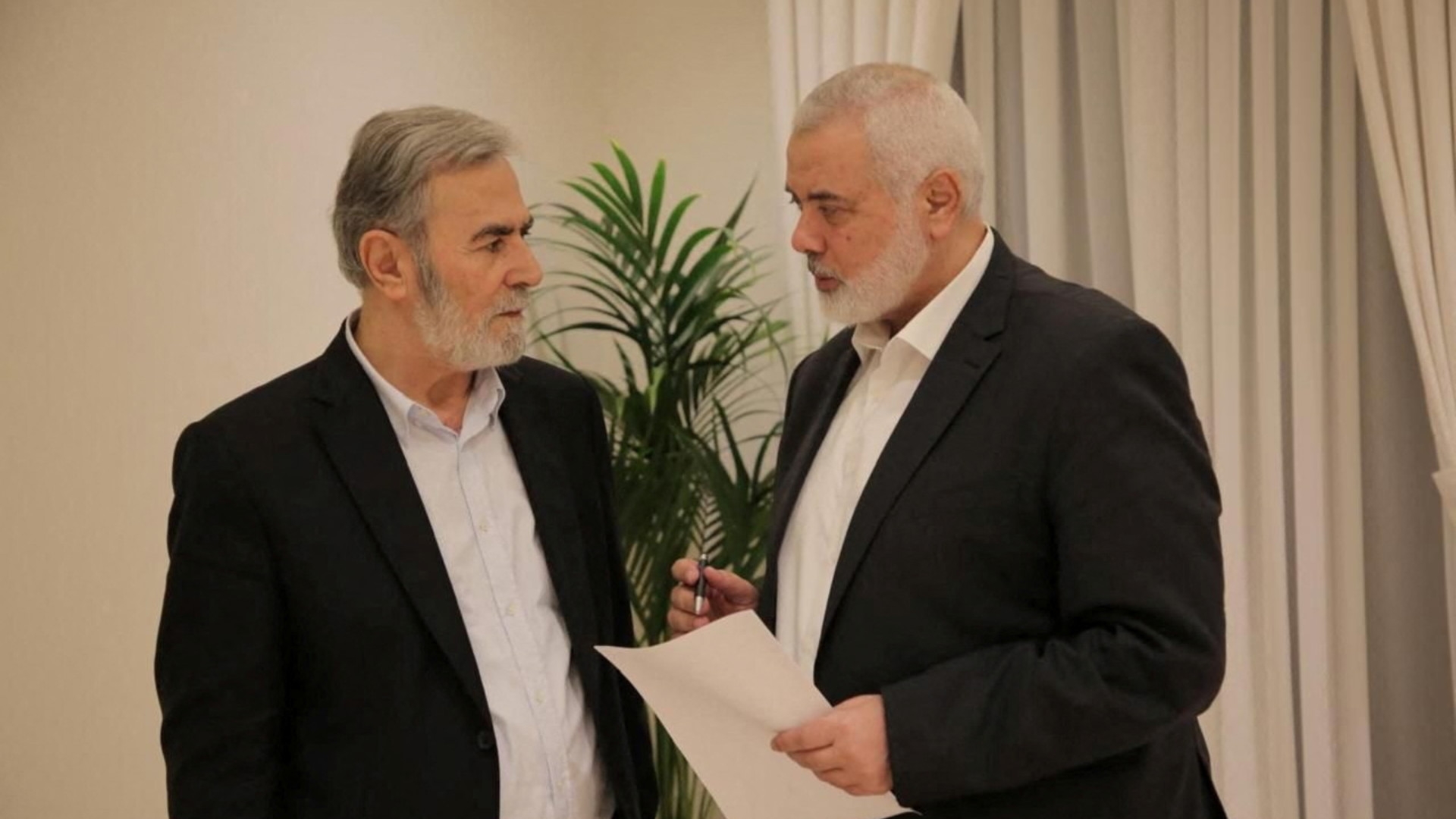 Hamas leader Ismail Haniyeh and Islamic Jihad leader Ziyad Al Nakhalaj discuss the ceasefire proposal before they respond to Qatari and Egyptian mediators in Doha, Qatar, 11 June 2024 (Hamas Media Office/Handout via Reuters) 