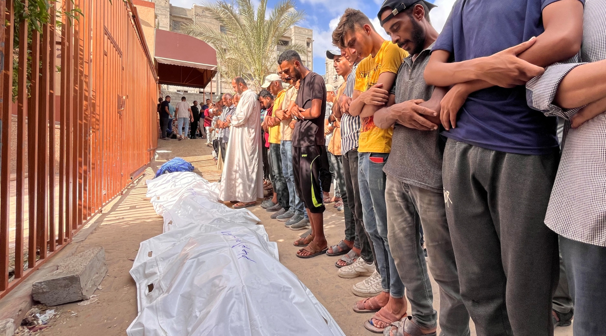 Mourners pray near the bodies of Palestinians killed in Israeli strikes at Nasser hospital in Khan Younis in the southern Gaza Strip, 8 August 2024 (Retuers/Hussam Al-Masri)