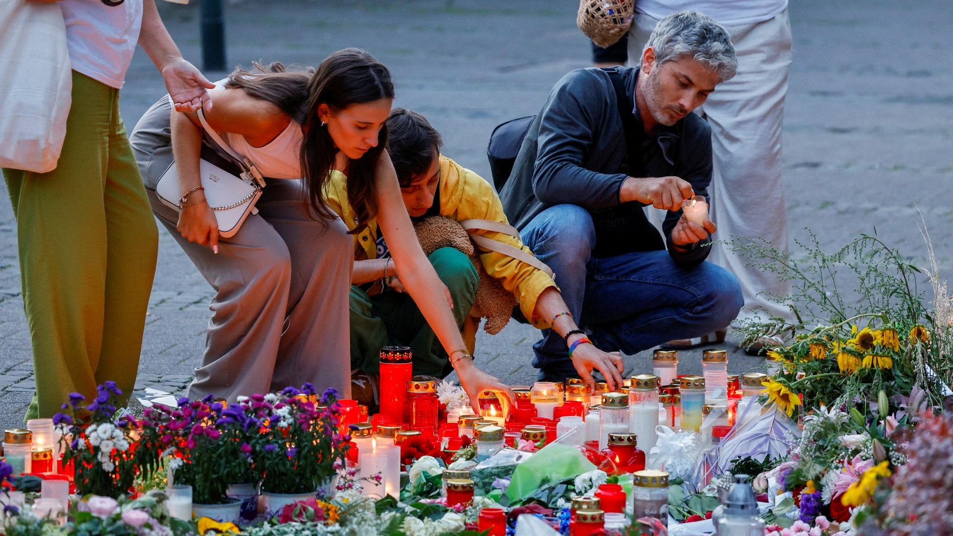 People light candles at a makeshift memorial on the day of protests on the streets of Solingen, following a stabbing rampage in the western German city in which several individuals were killed and injured, in Solingen, Germany, 26 August 2024 (Wolfgang Rattay/Reuters) 