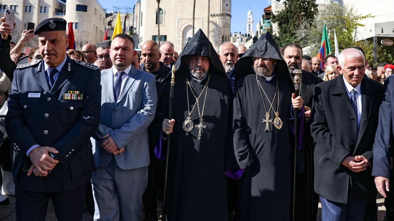Patriarch Nurhan Manougian (C) of the Armenian Patriarchate of Jerusalem arrives to the Church of the Nativity in the occupied West Bank city of Bethlehem, to celebrate the Nativity of Jesus, on 18 January (AFP)
