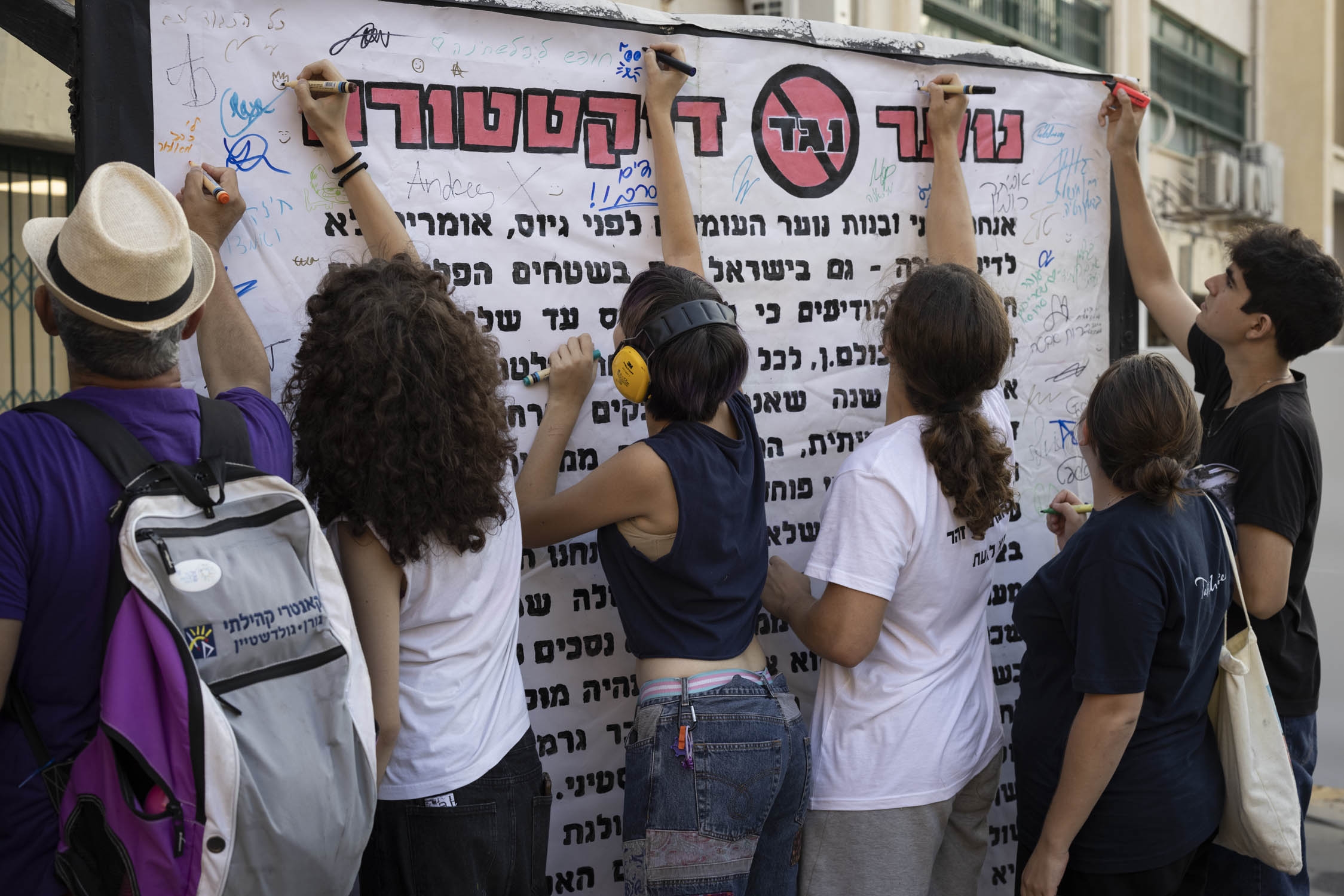 Activists sign a statement at the Herzliya Hebrew Gymnasium high school in central Tel Aviv for the Youth Against Dictatorship event (MEE/Oren Ziv)