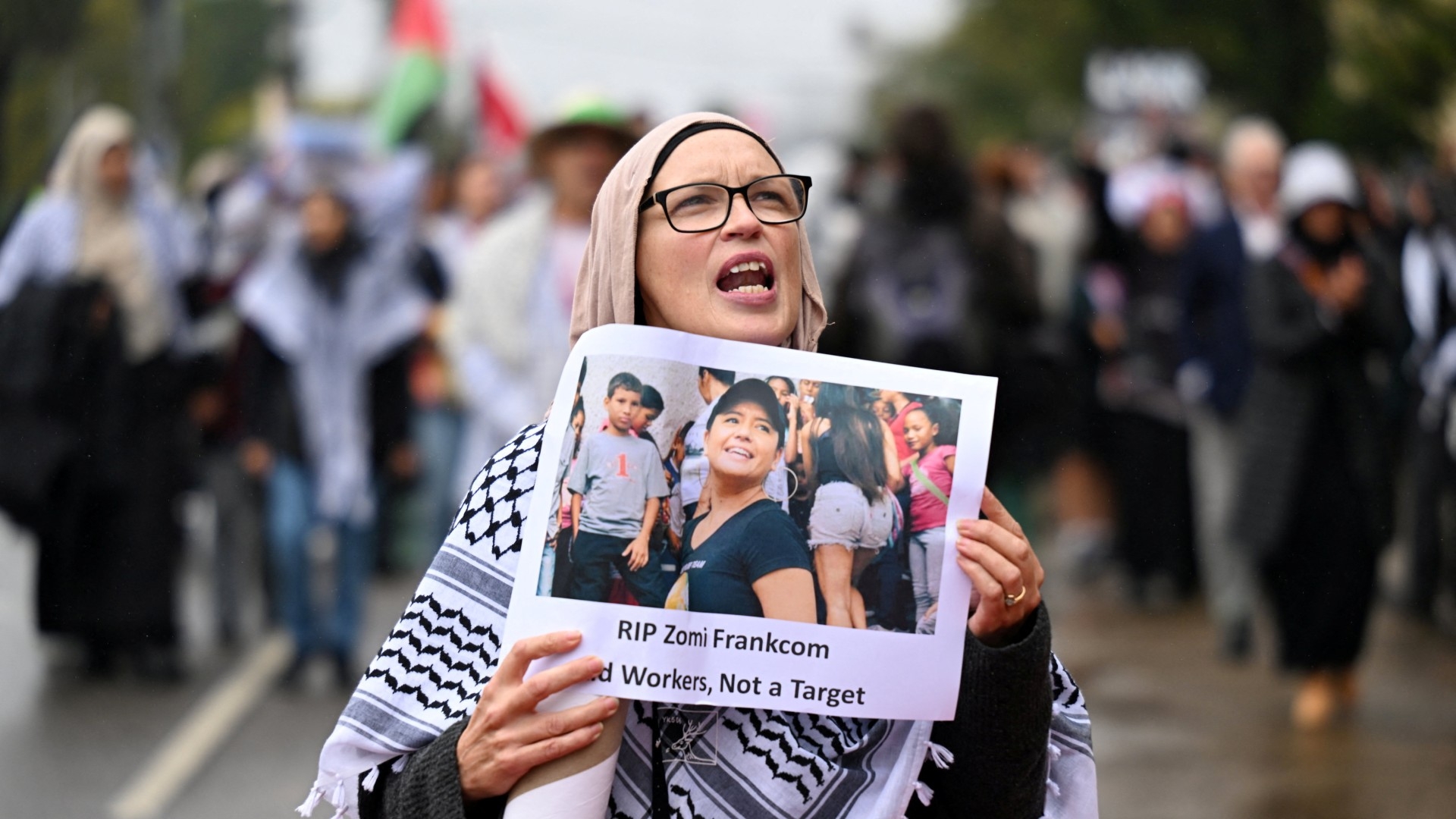 Lors d’une manifestation pro-palestinienne, à Melbourne, en Australie, le 3 avril 2024, une participante tient une affiche avec une photo de l’Australienne Lalzawmi « Zomi » Frankcom, 43 ans, tuée avec six autres travailleurs humanitaires de l’ONG américaine World Central Kitchen (WCK), par une frappe aérienne israélienne à Gaza (Reuters)