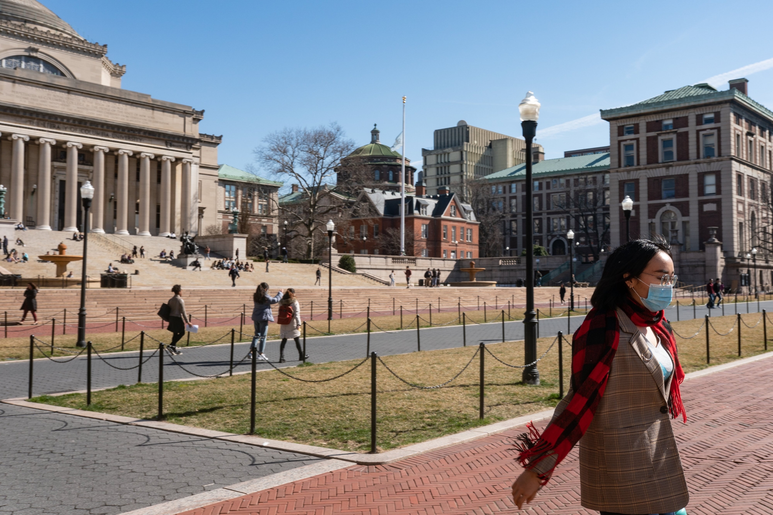 A woman wearing a protective mask walks on the Columbia University campus on 9 March, 2020 in New York City