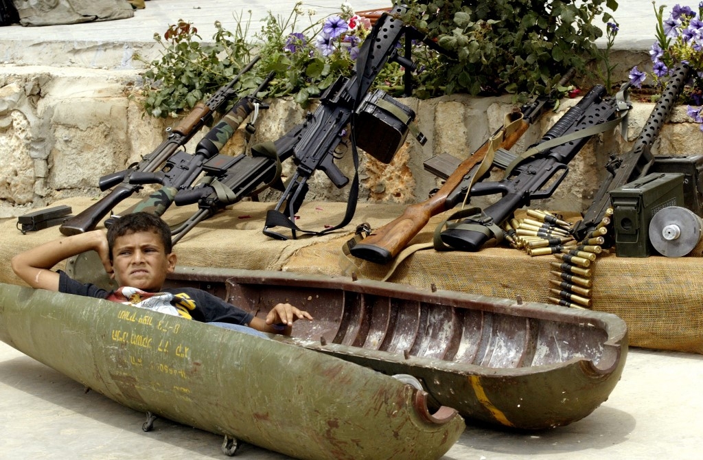 A Lebanese boy relaxes on 15 July 2007 inside a shell dropped by Israeli warplanes during the previous year's war with Hezbollah in the southern village of Aita al-Shaab (AFP/Mahmoud Zayyat)