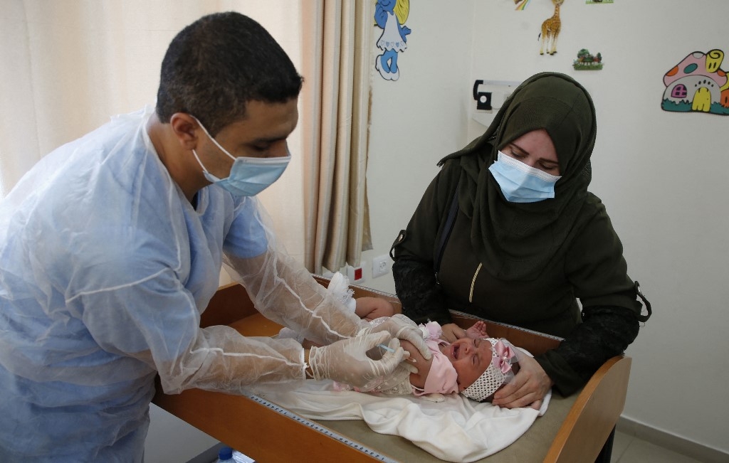 A Unrwa employee provides Polio vaccine for children in a clinic in Bureij refugee camp central of Gaza Strip on 9 September 2020 (Mohammed Abed/AFP)