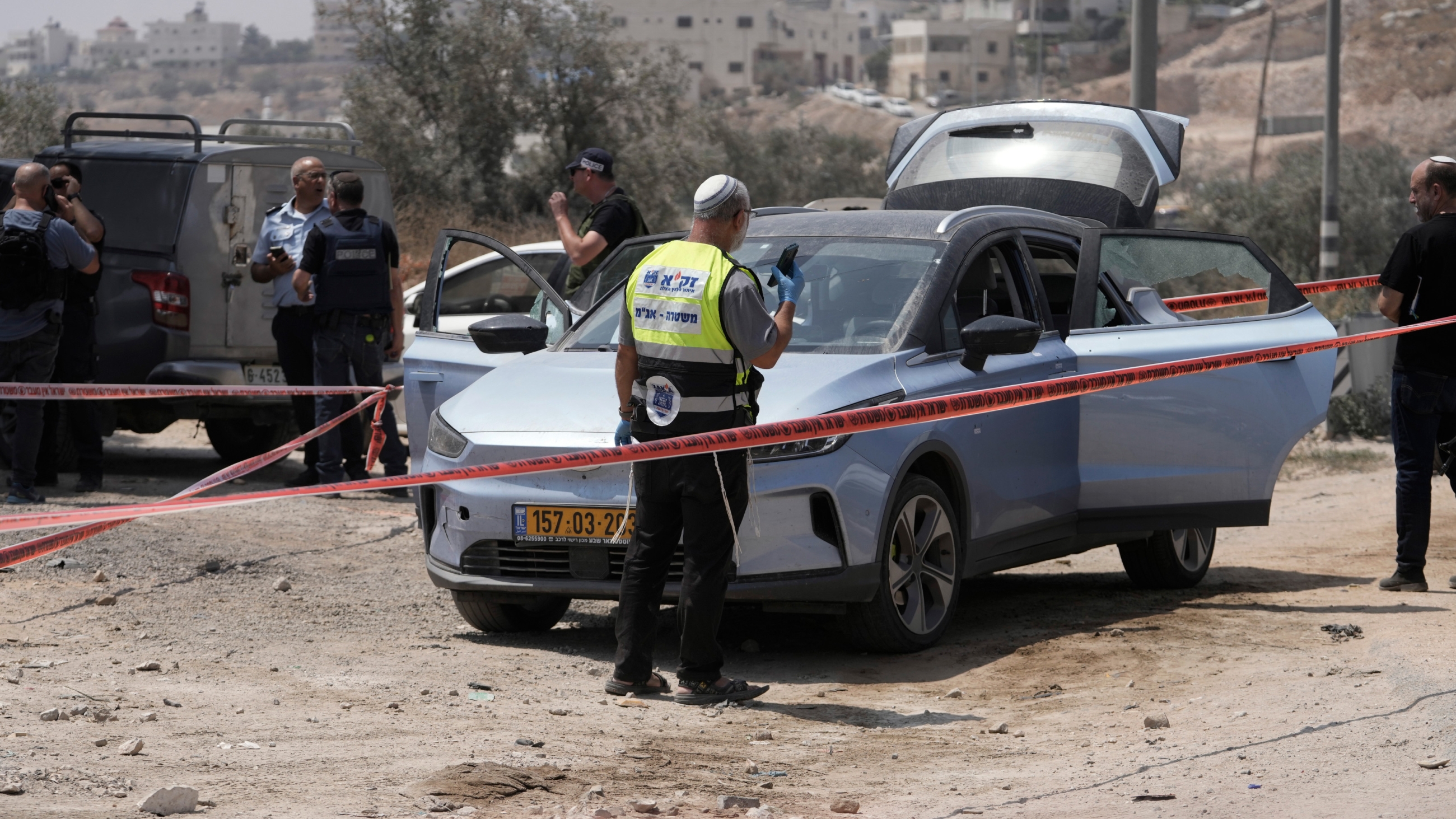 Israeli rescue and recovery team works at the scene of a shooting near the West Bank city of Hebron, on Monday 21 August 2023 (AP)