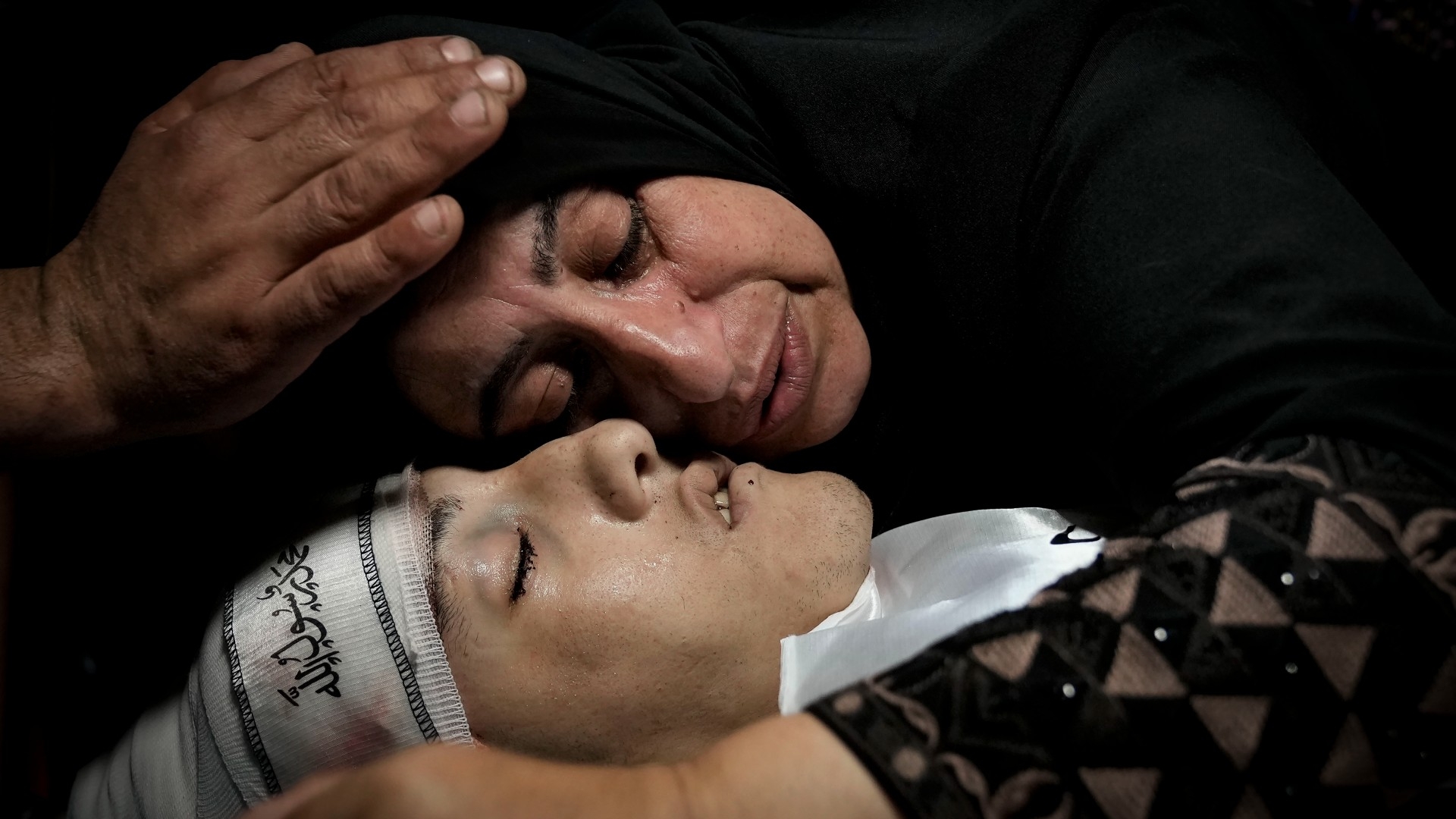 Relatives mourn over the body of a 19-year-old Palestinian killed by Israeli troops, in Jenin on 8 October (AP)