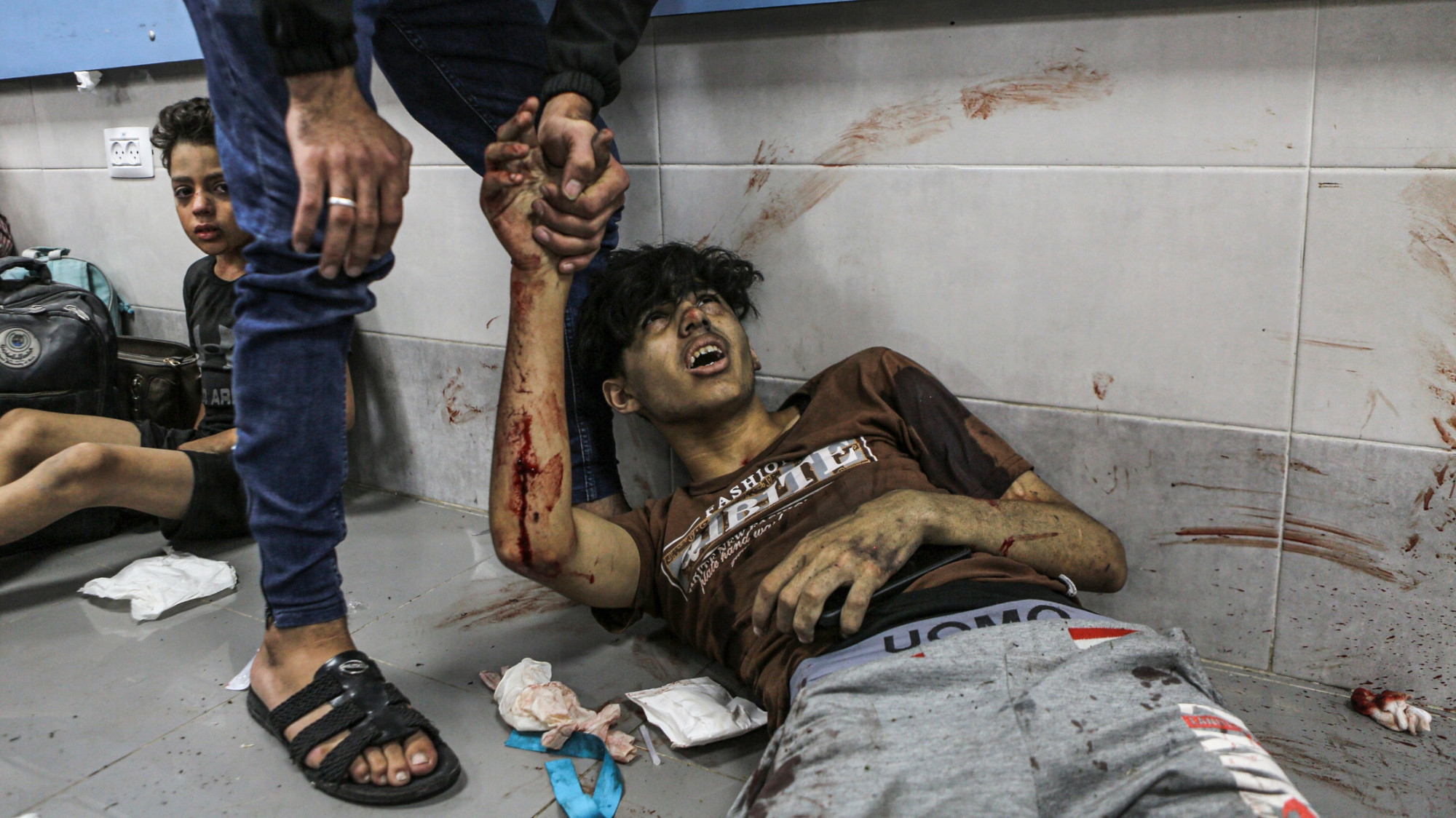 Wounded Palestinians lay on the floor at al-Shifa hospital following an Israeli air strike at a City hospital on 17 October 2023 (AP)