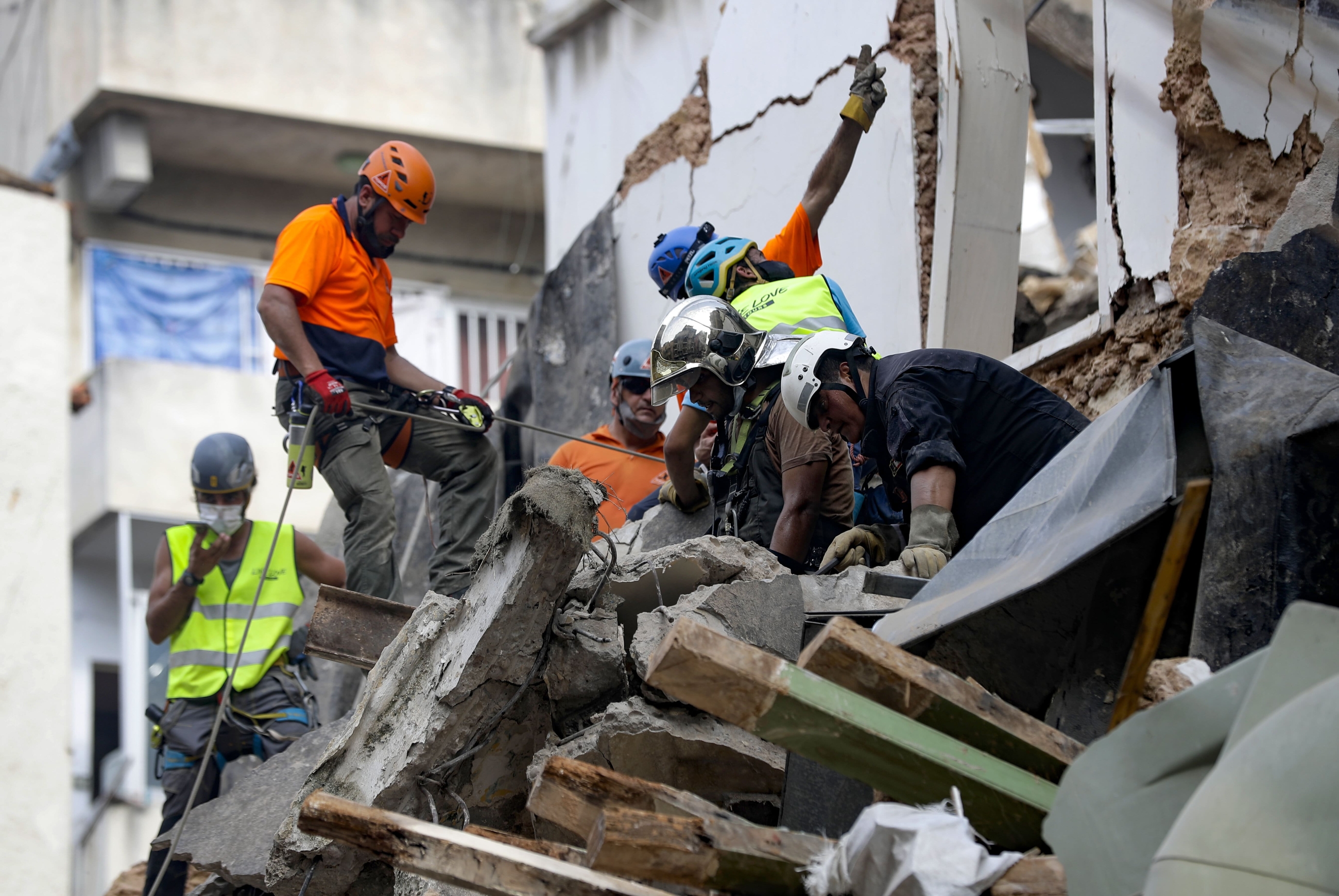 Rescue workers dig through the rubble of a badly damaged building in Beirut's Gemmayzeh district