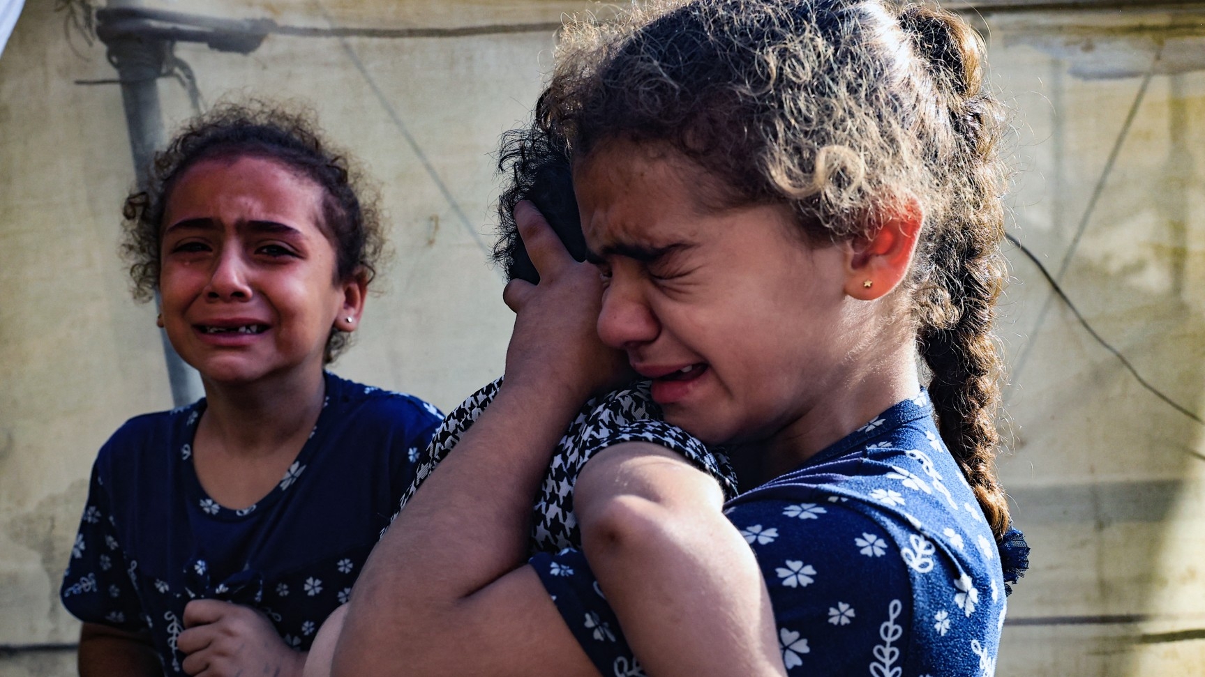 Children react during the funeral of the Faojo family, killed in Israeli bombing on Rafah in the southern Gaza Strip on 11 November, 2023 (AFP)