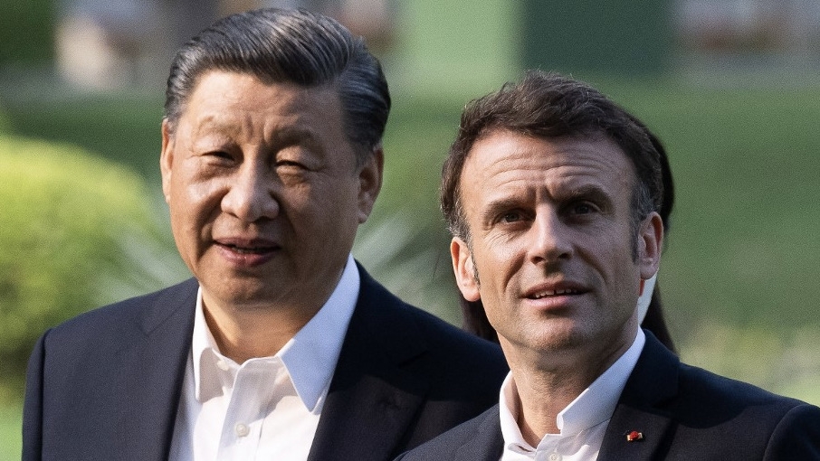 Chinese President Xi Jinping (L) and French President Emmanuel Macron (R) in the garden of the residence of the governor of Guangdong, China, on 7 April 2023 (AFP)