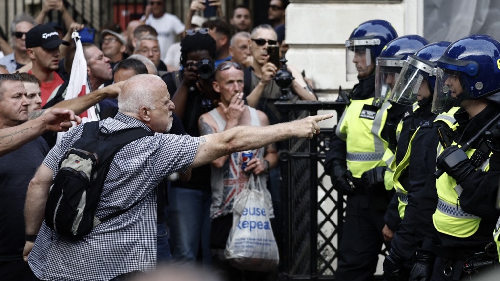 Protestors remonstrate with police officers in London on 31 July 2024 (Benjamin Cremel/AFP)