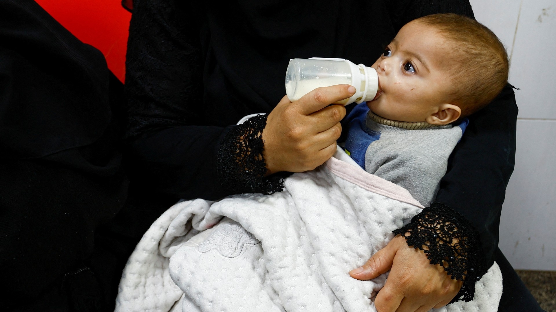 A Palestinian boy is bottle-fed at Abu Yousef al-Najjar hospital, while Gaza residents face crisis levels of hunger and soaring malnutrition, in Rafah in the southern Gaza Strip 24 January 2024 (Reuters)